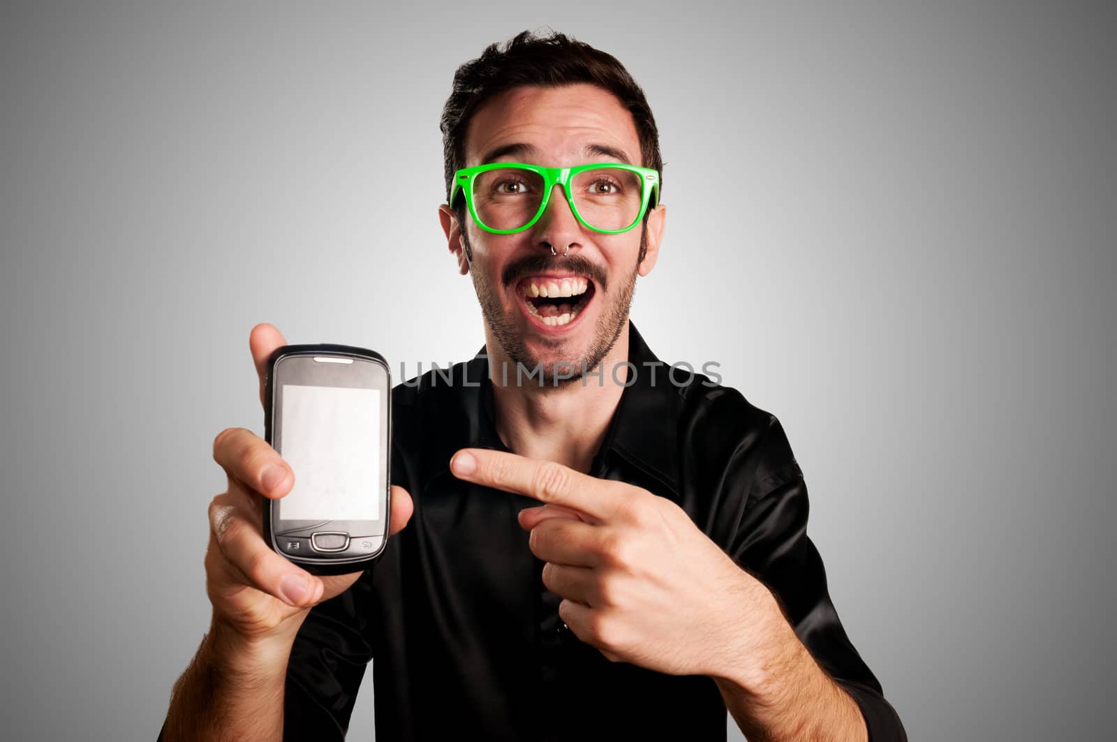 happy man showing phone on gray background