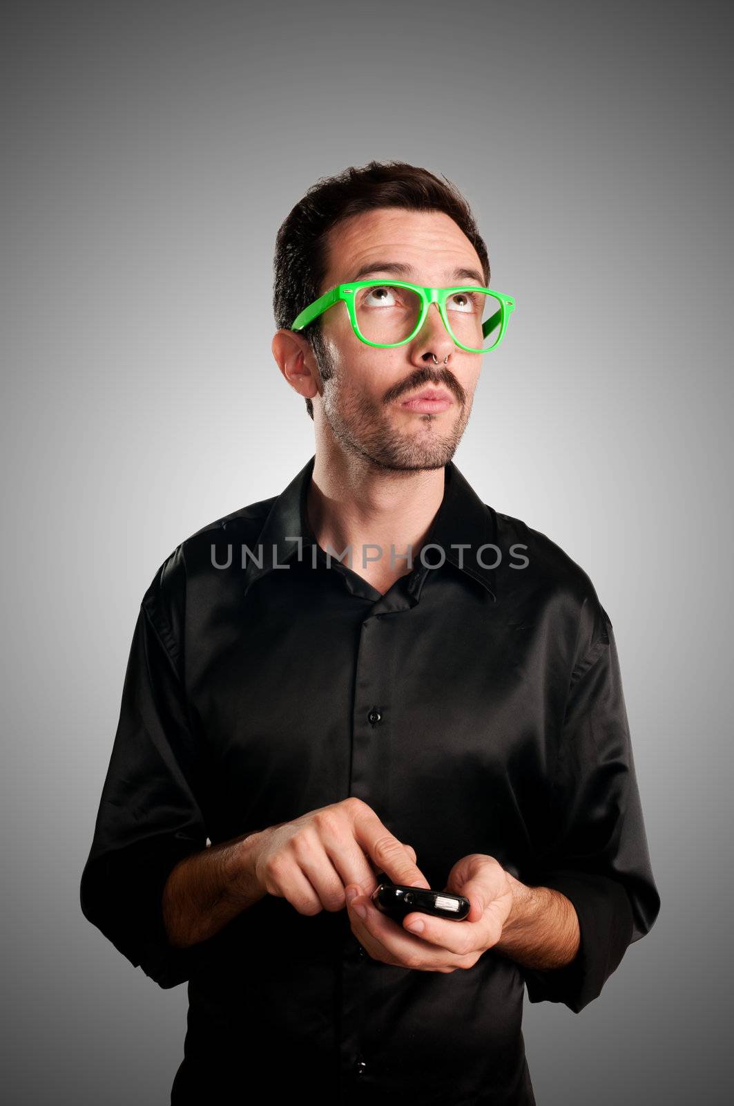 thinking man holding phone on gray background