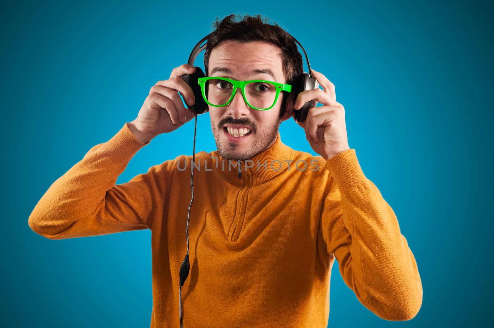 guy with headphones listening to music on green background