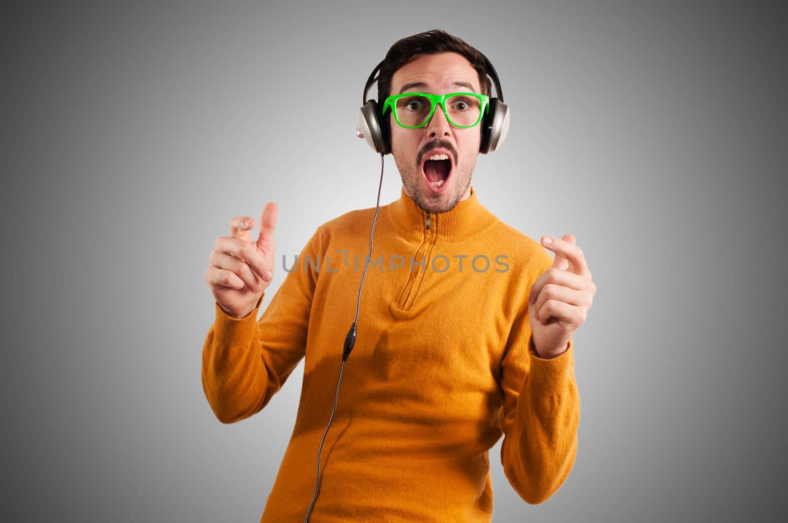 guy with headphones listening to music on green background