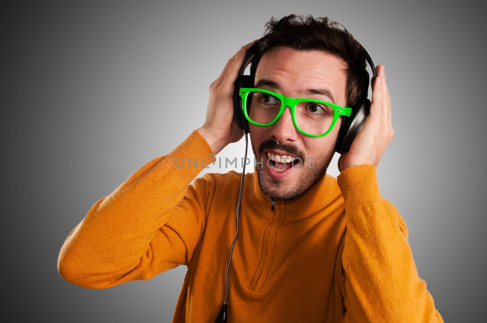 guy with headphones listening to music on green background