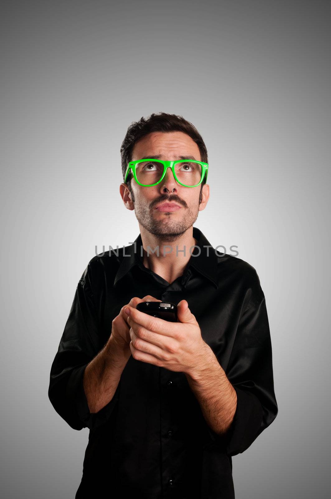 thinking man holding phone on gray background