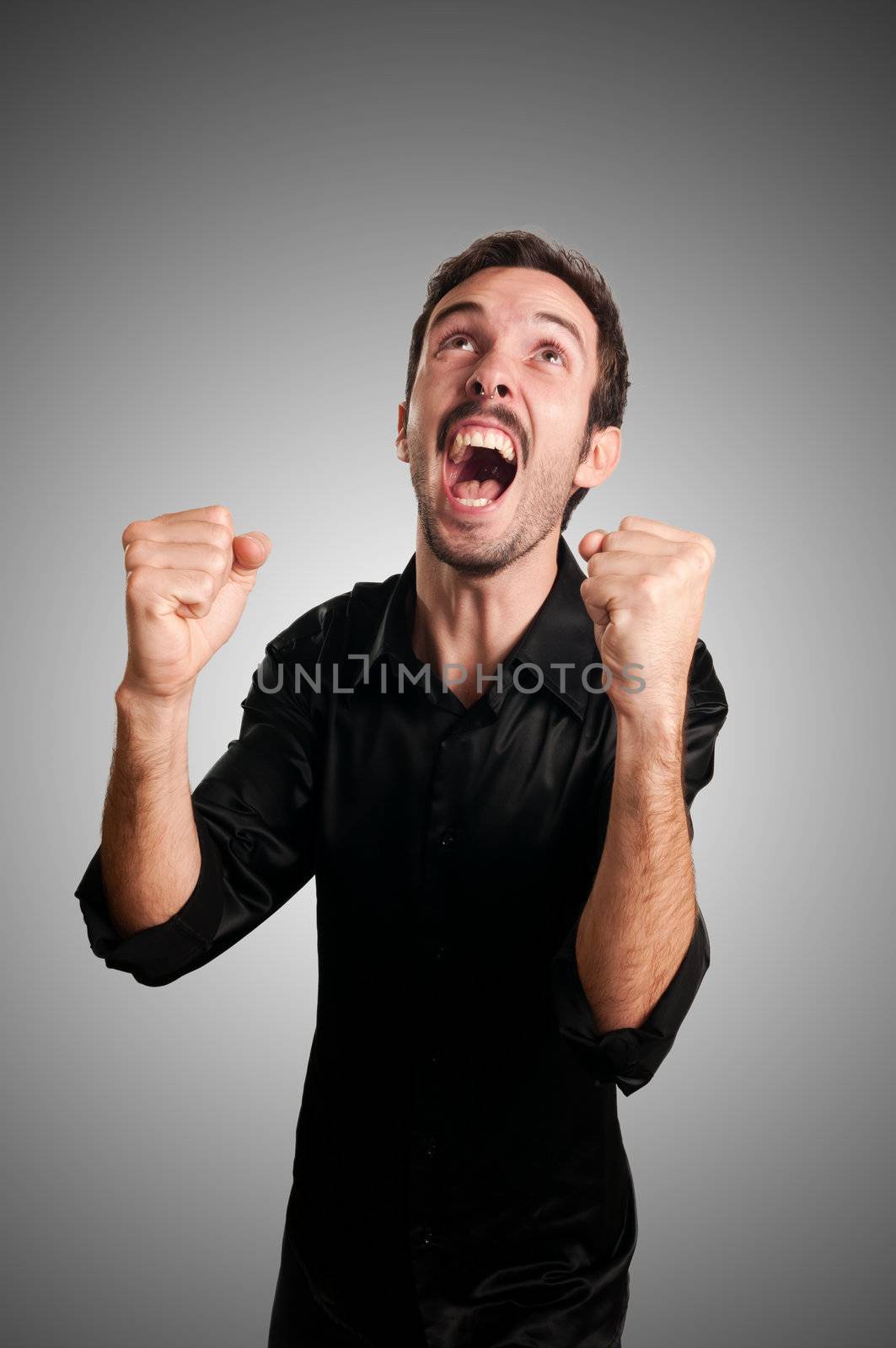 successful business man screaming on blue background