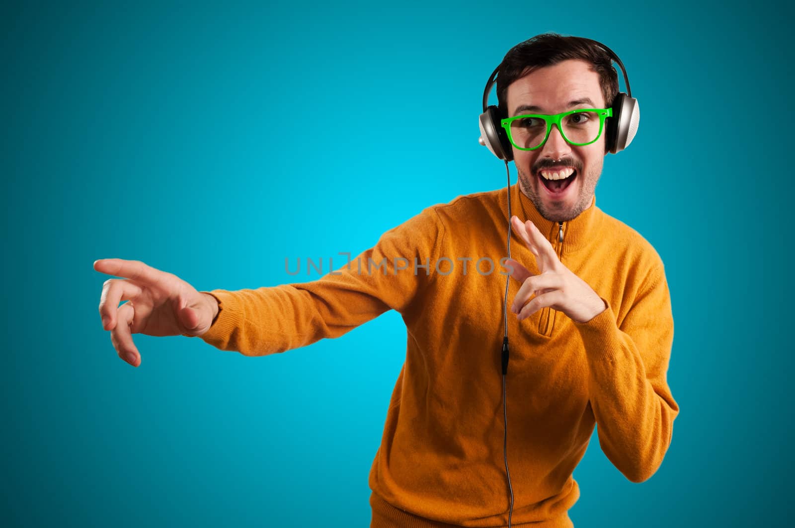 guy with headphones listening to music on green background