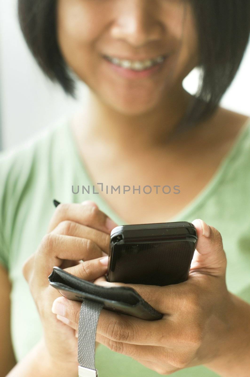 close up of a woman using her smartphone or cellphone with smiles.