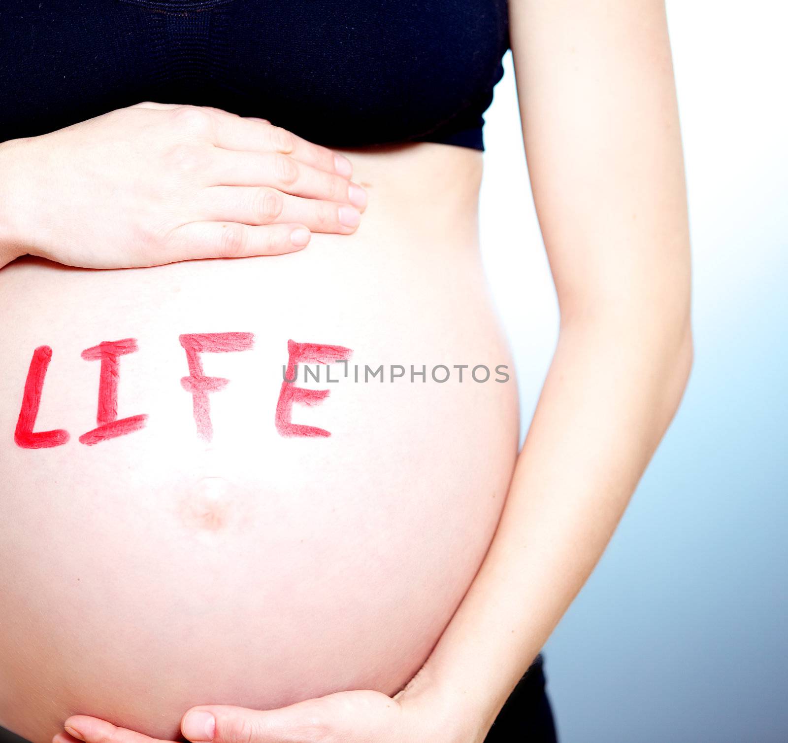 Pregnant woman with the word LIFE on her tummy by langstrup