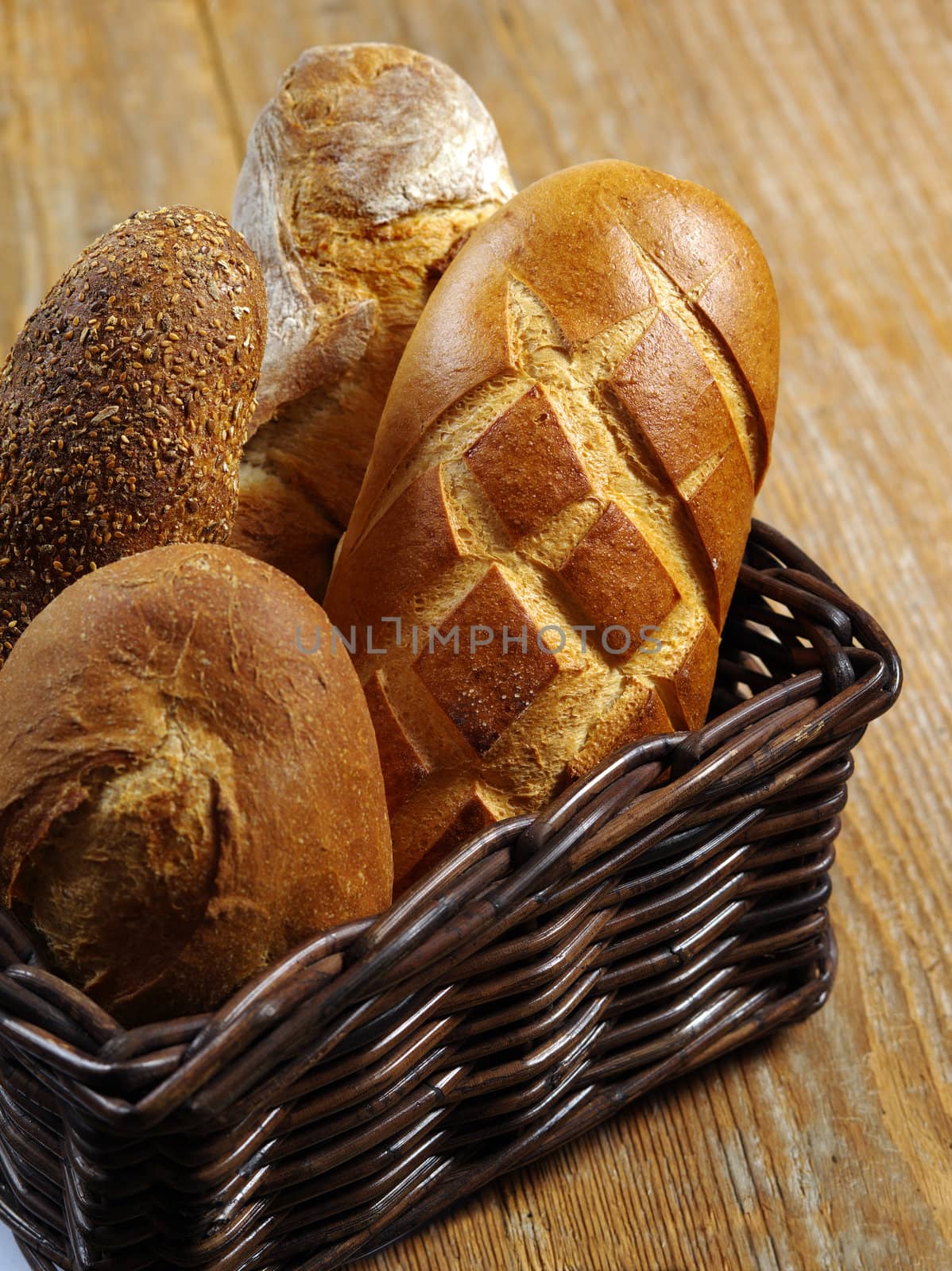 Photo of loaves of uncut bread resting in a wicker basket.
