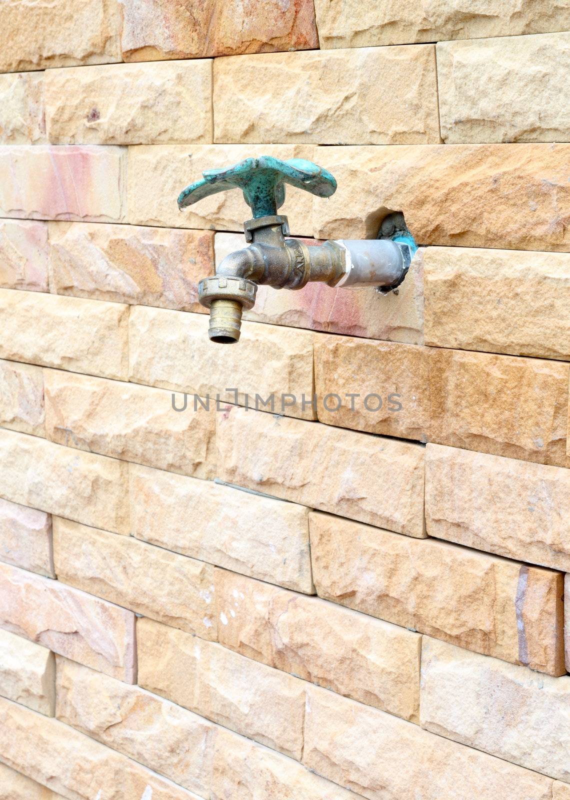 faucet on brick wall background