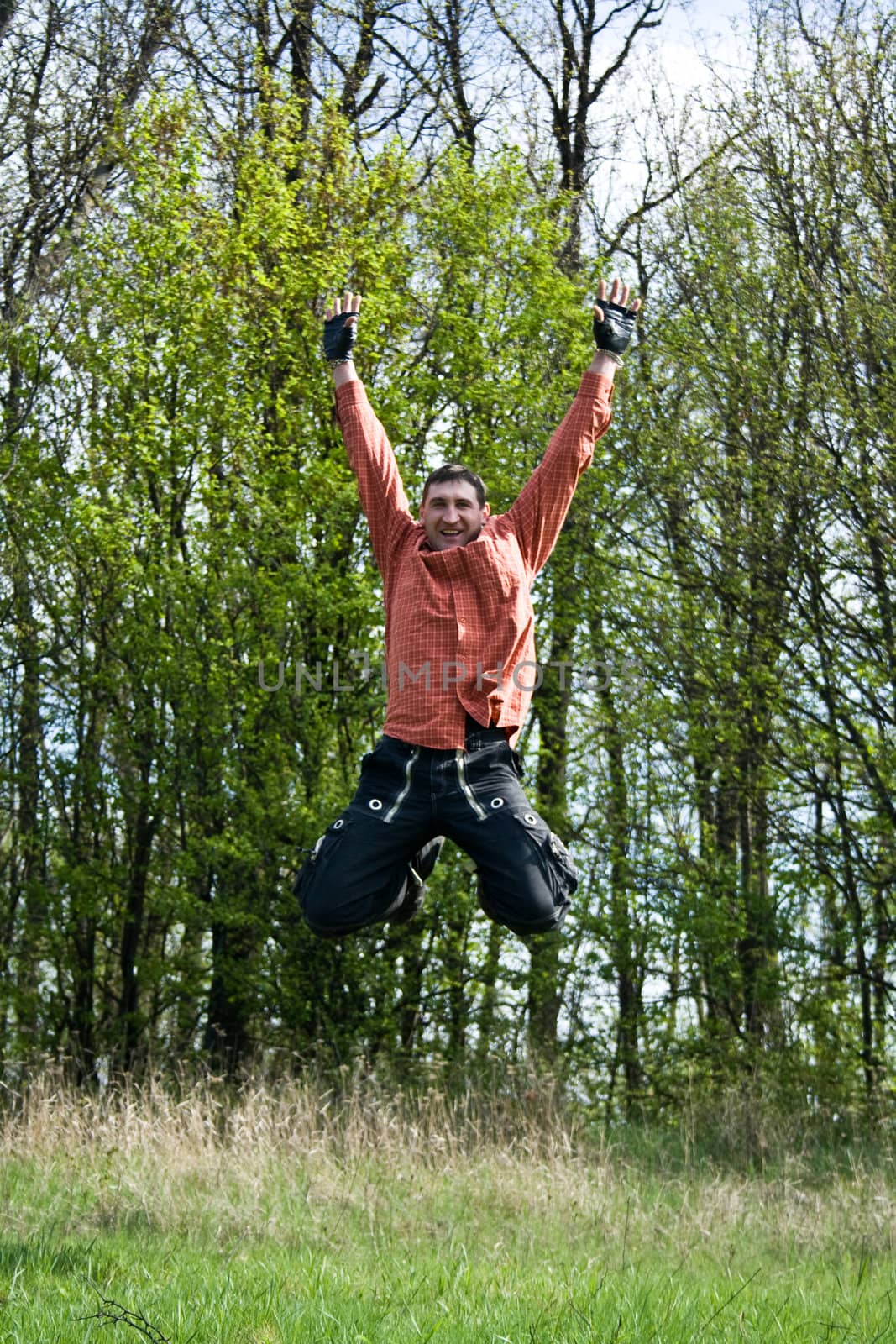 happy man on meadow jumping in the air