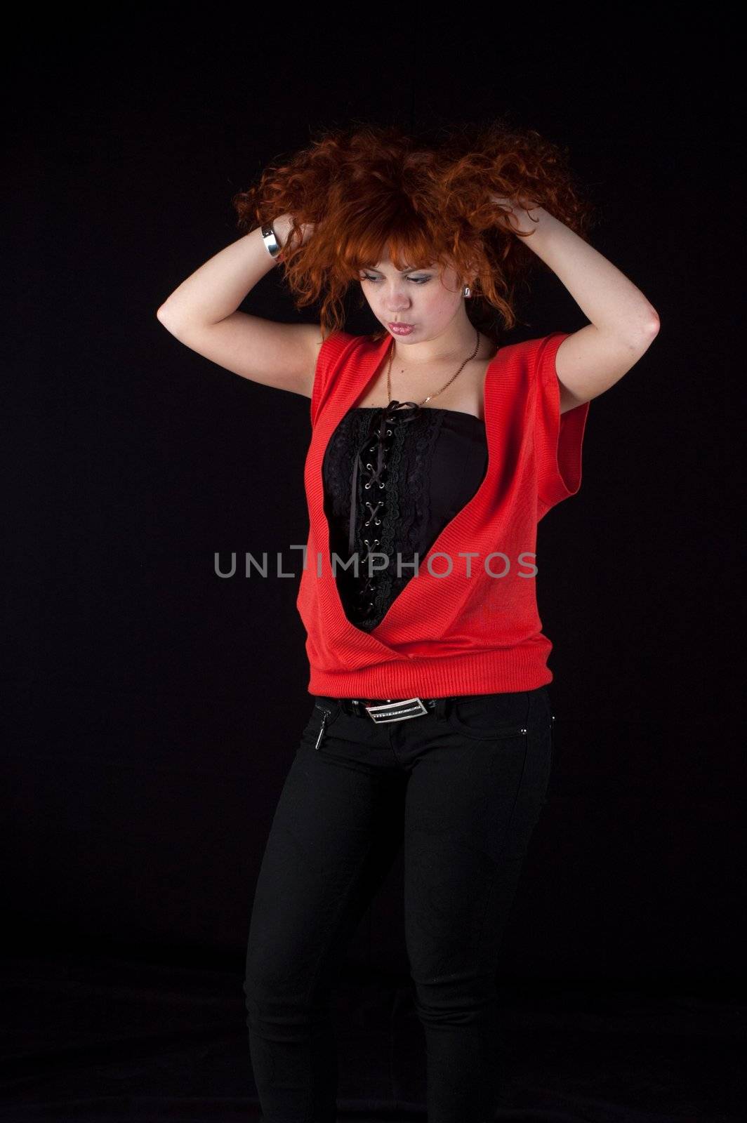 Portrait of beautiful redhead girl on black background