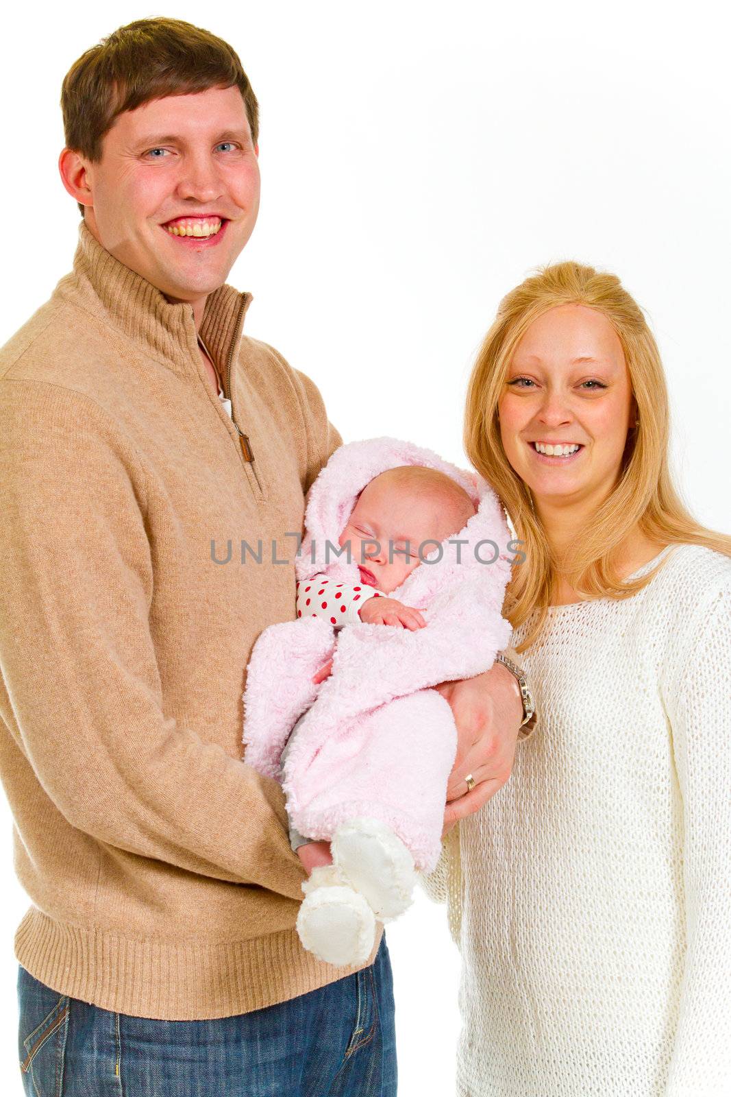 A family portrait of three people in the studio including mother father and newborn baby girl.