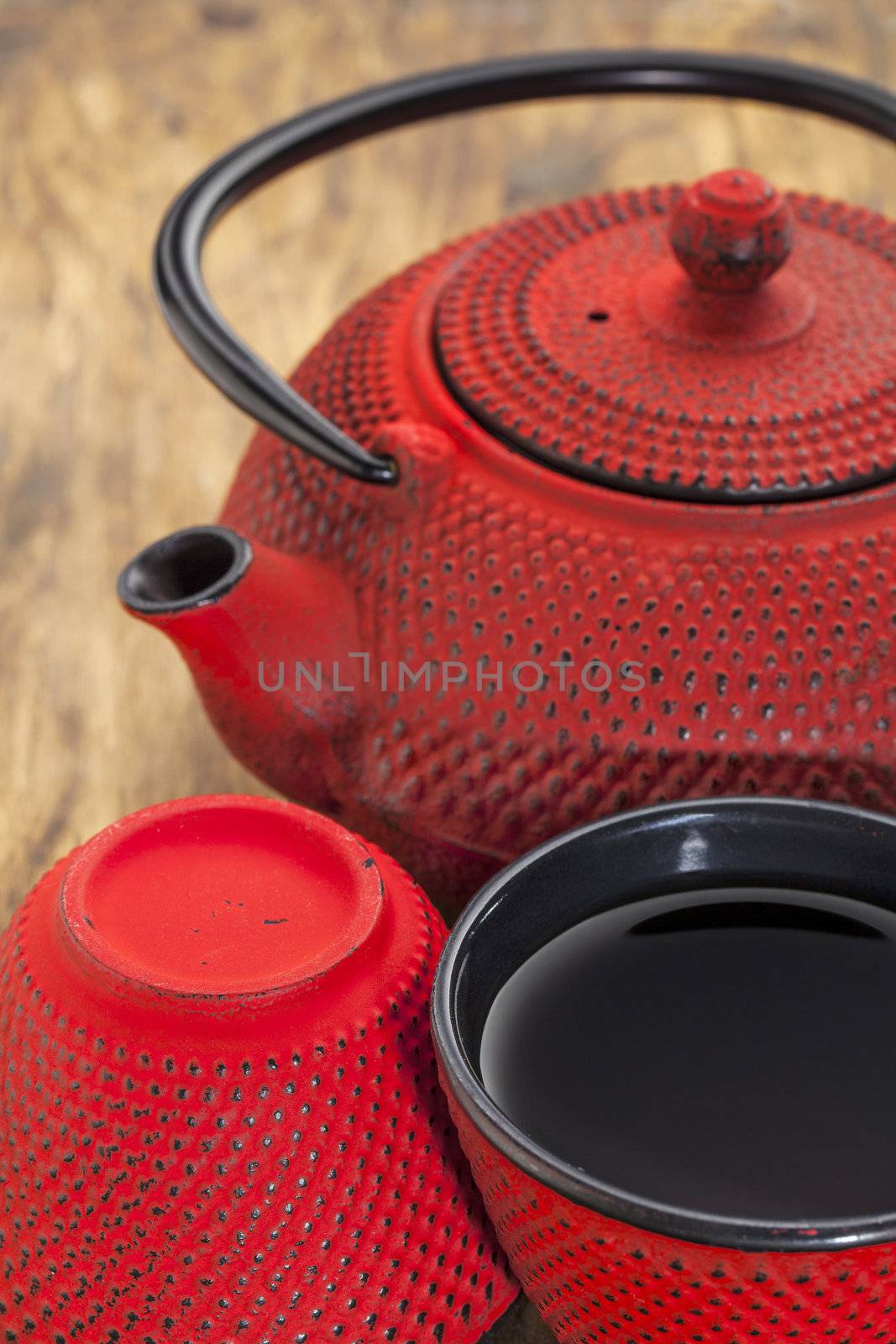 red hobnail tetsubin with a cup of tea - a detail of a traditional cast iron Japanese teapot set