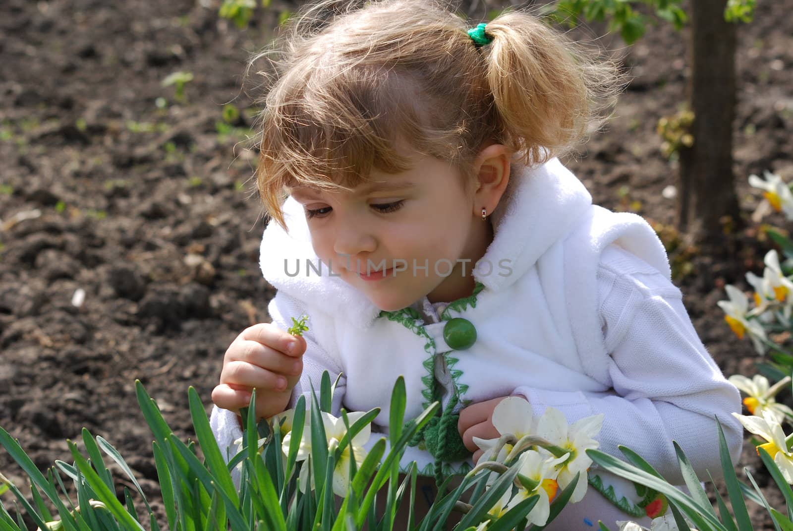 Little girl in garden with flower