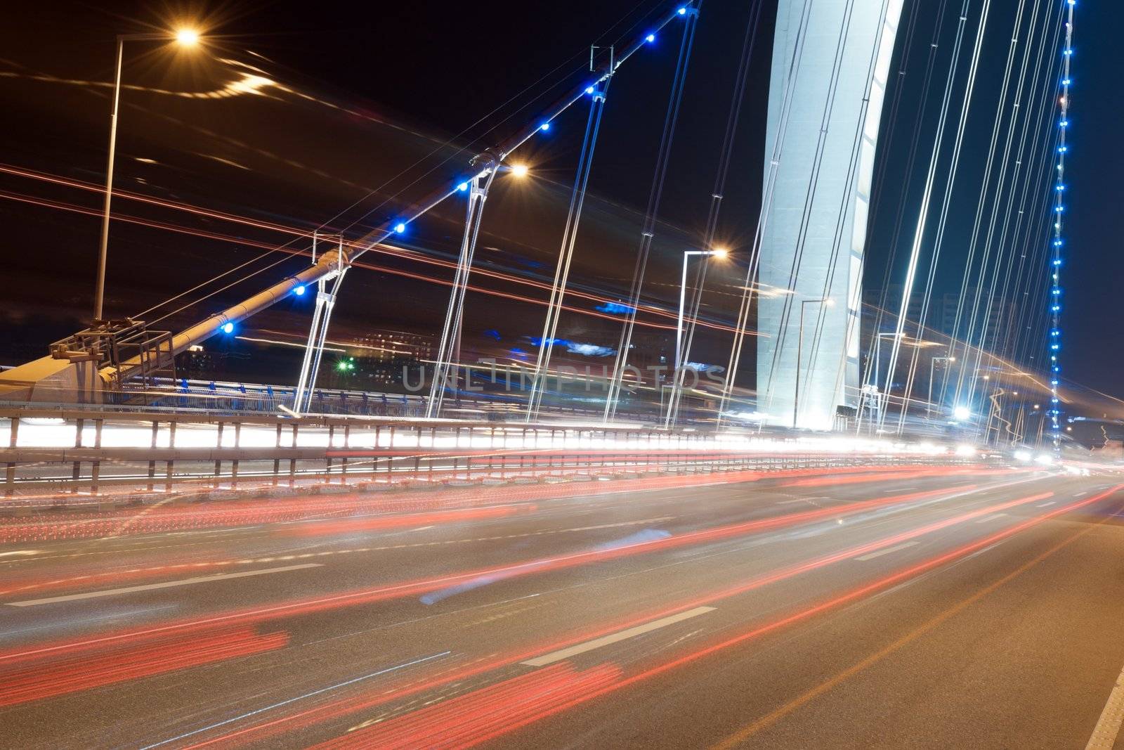 Urban traffic on modern bridge at night