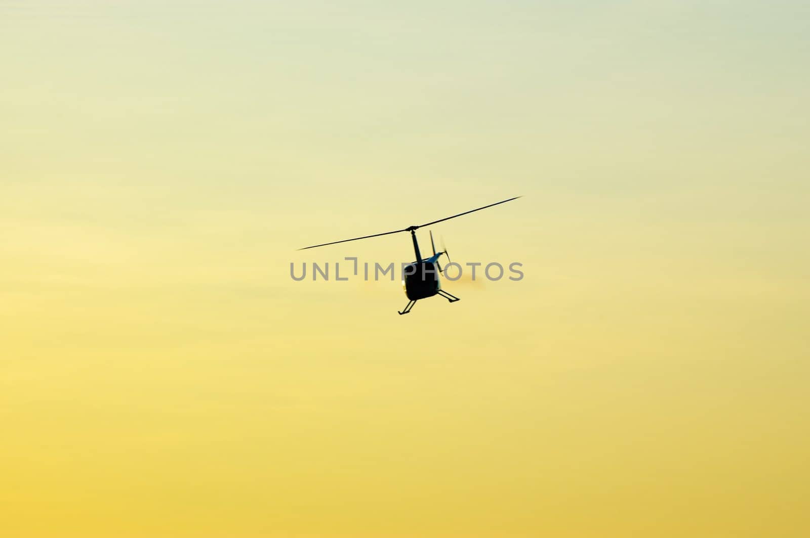 Helicopter flying over the sky at sunset