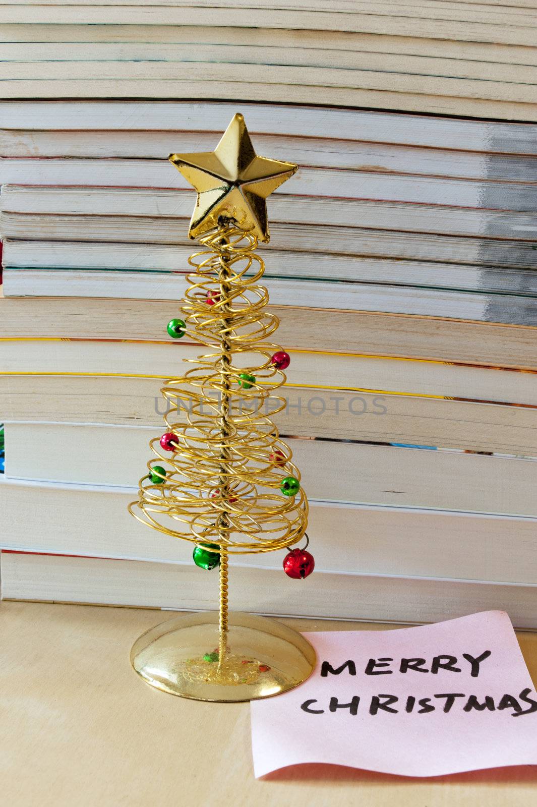 Merry Christmas memo under the Christmas tree with books as background