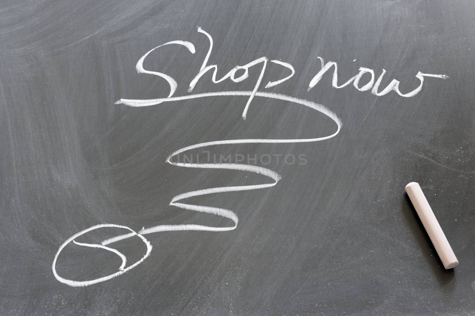 "Shop now" word and computer mouse drawn on the chalkboard