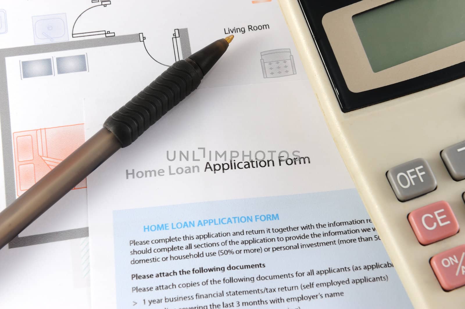 Home loan application form with calculator and pen nearby