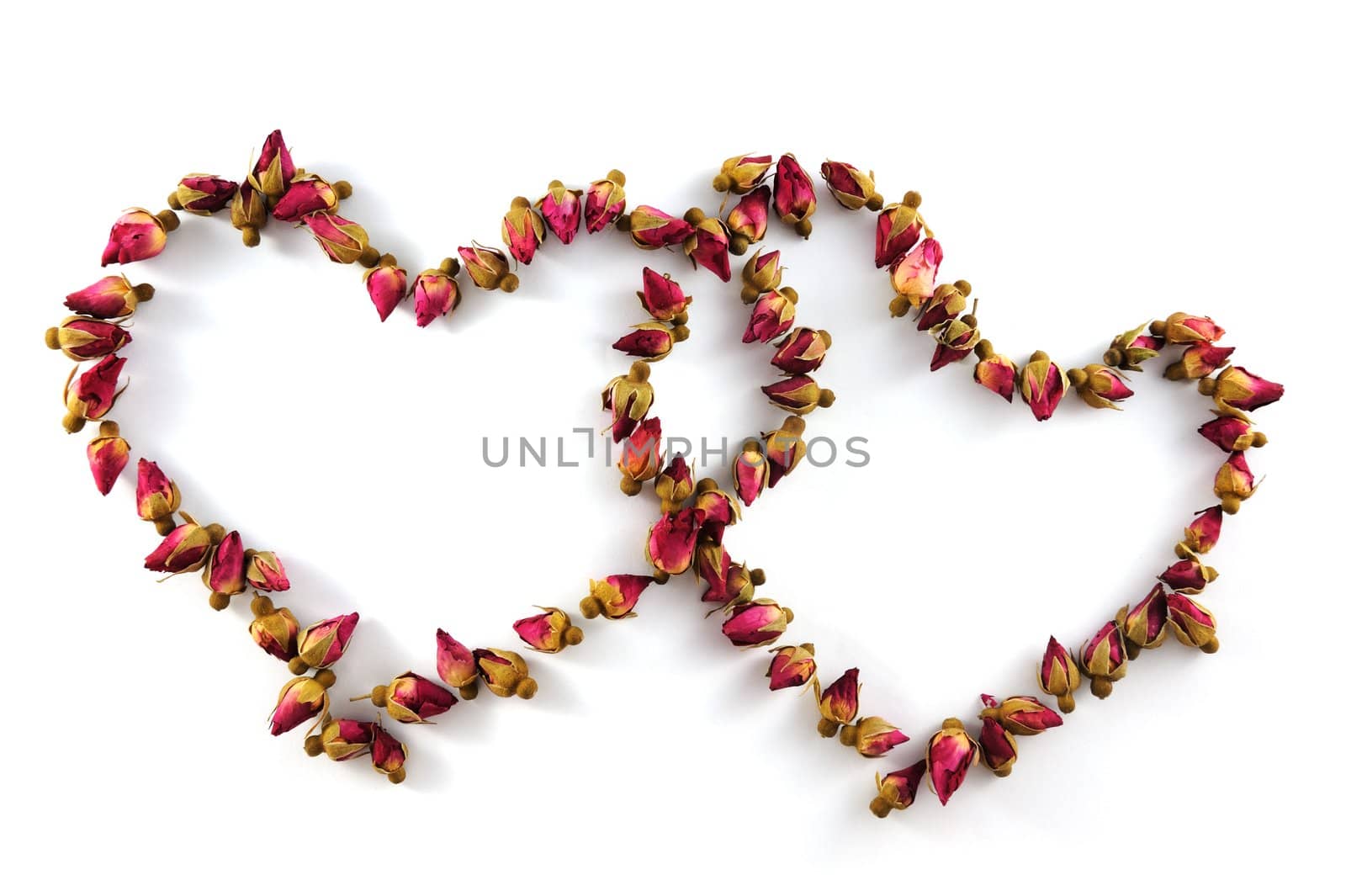 Two heart symbols made of dried flowers on white background