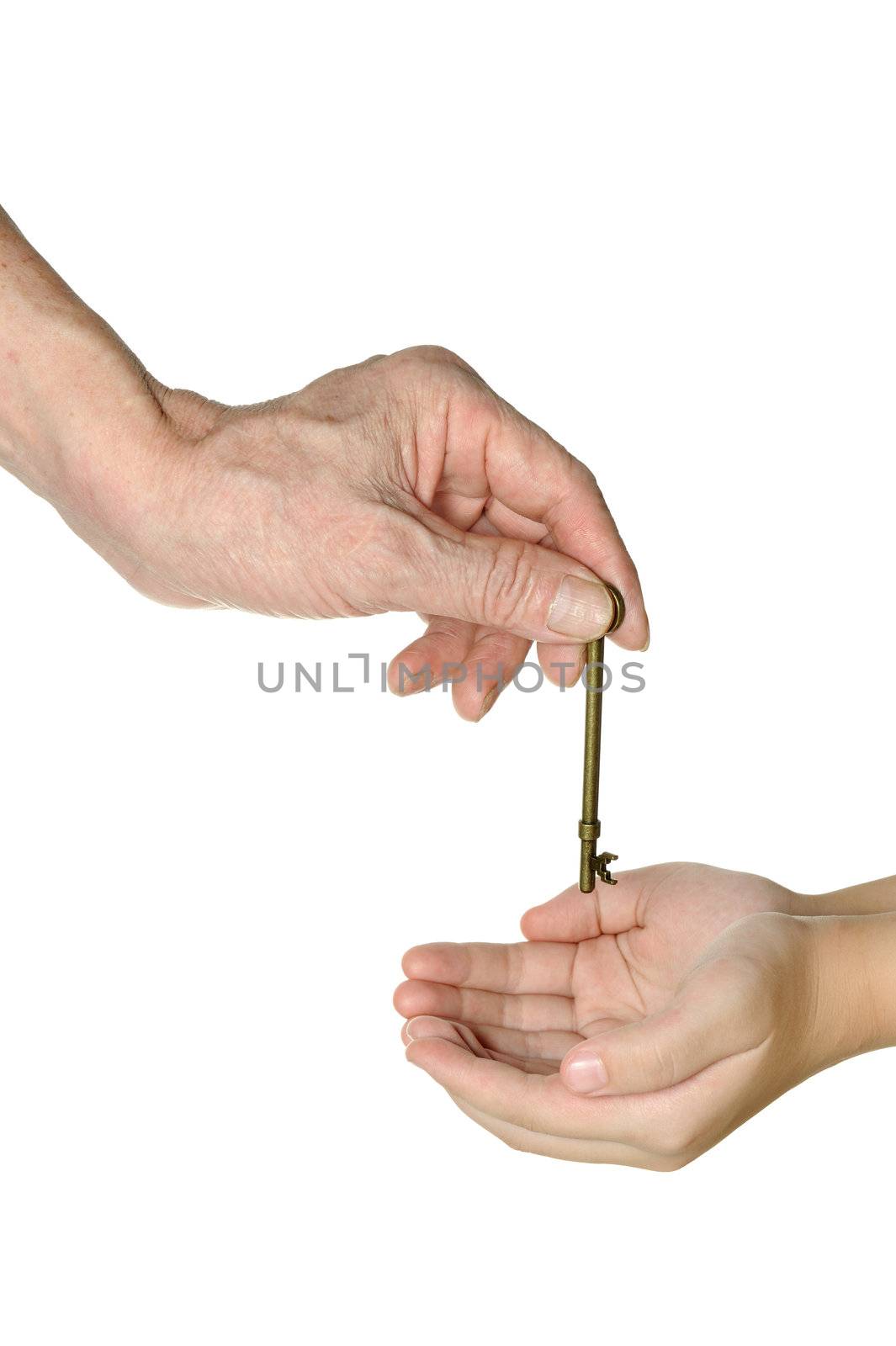 Two hands passing an old key isolated on white background