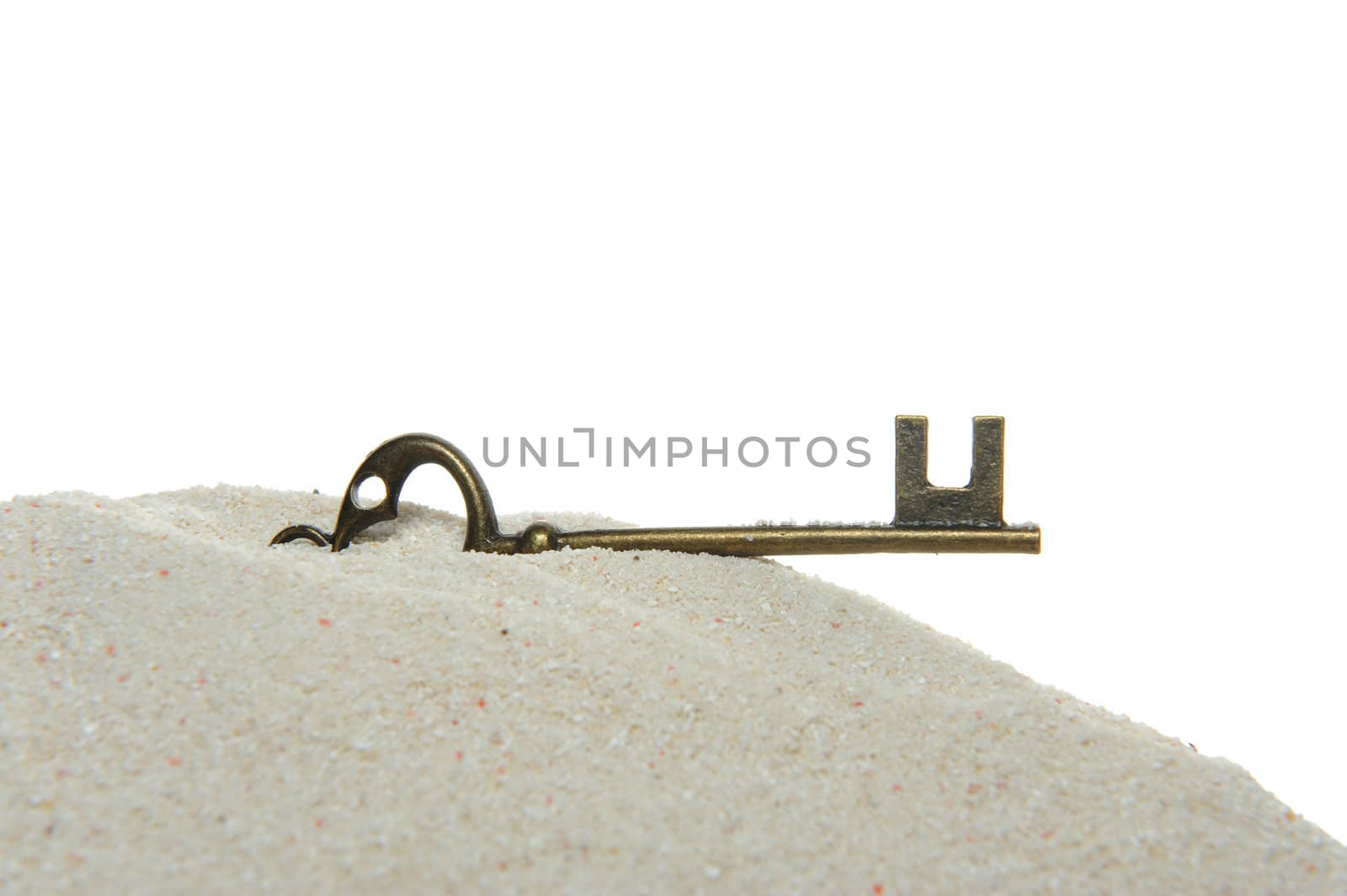 Key on sand isolated on white background