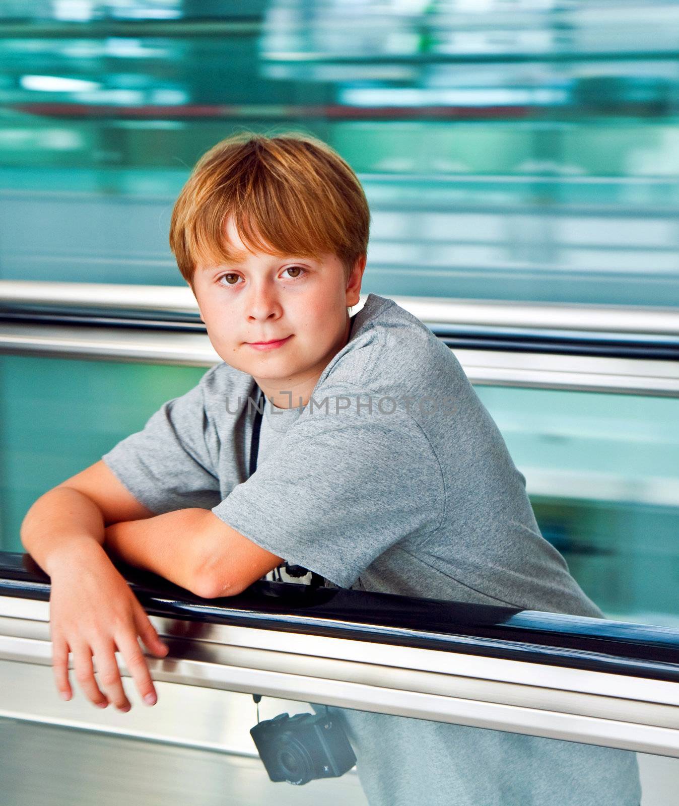 boy in the departure hall  in the new Airport Suvarnabhumi in Bangkok on a moving staircase