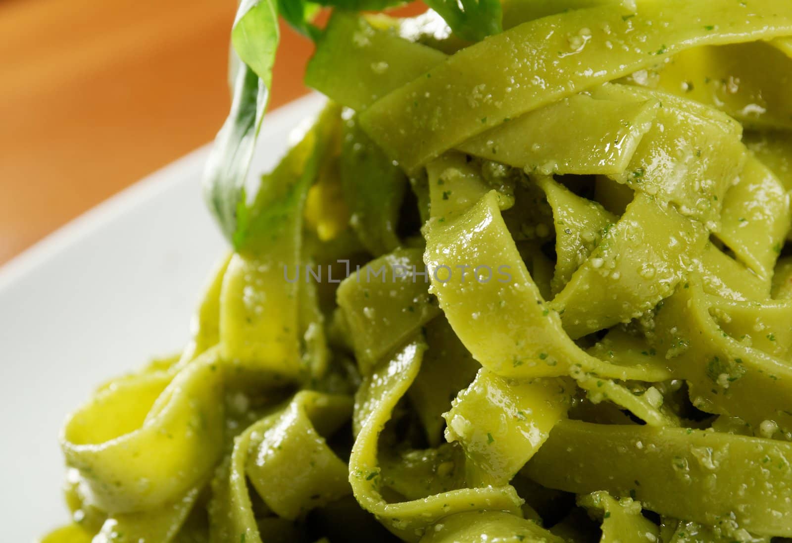 Tagliatelle pasta with pesto on light plate. closeup
