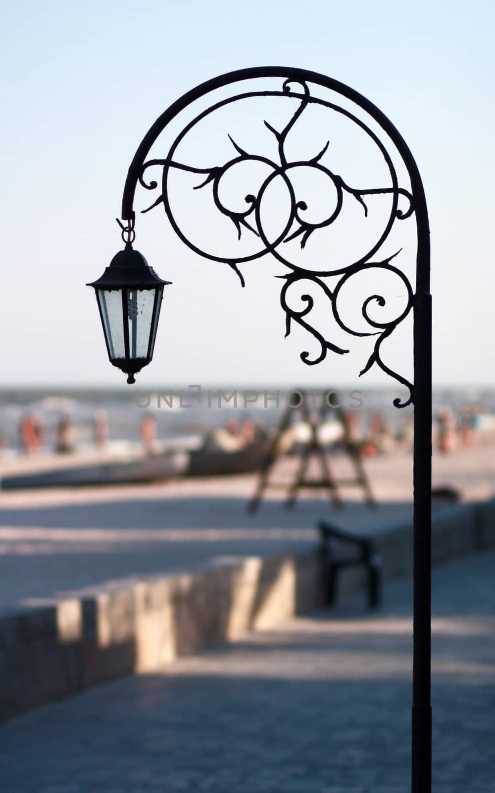 Silhouette wrought park lantern against the beach and sea in sum by pt-home