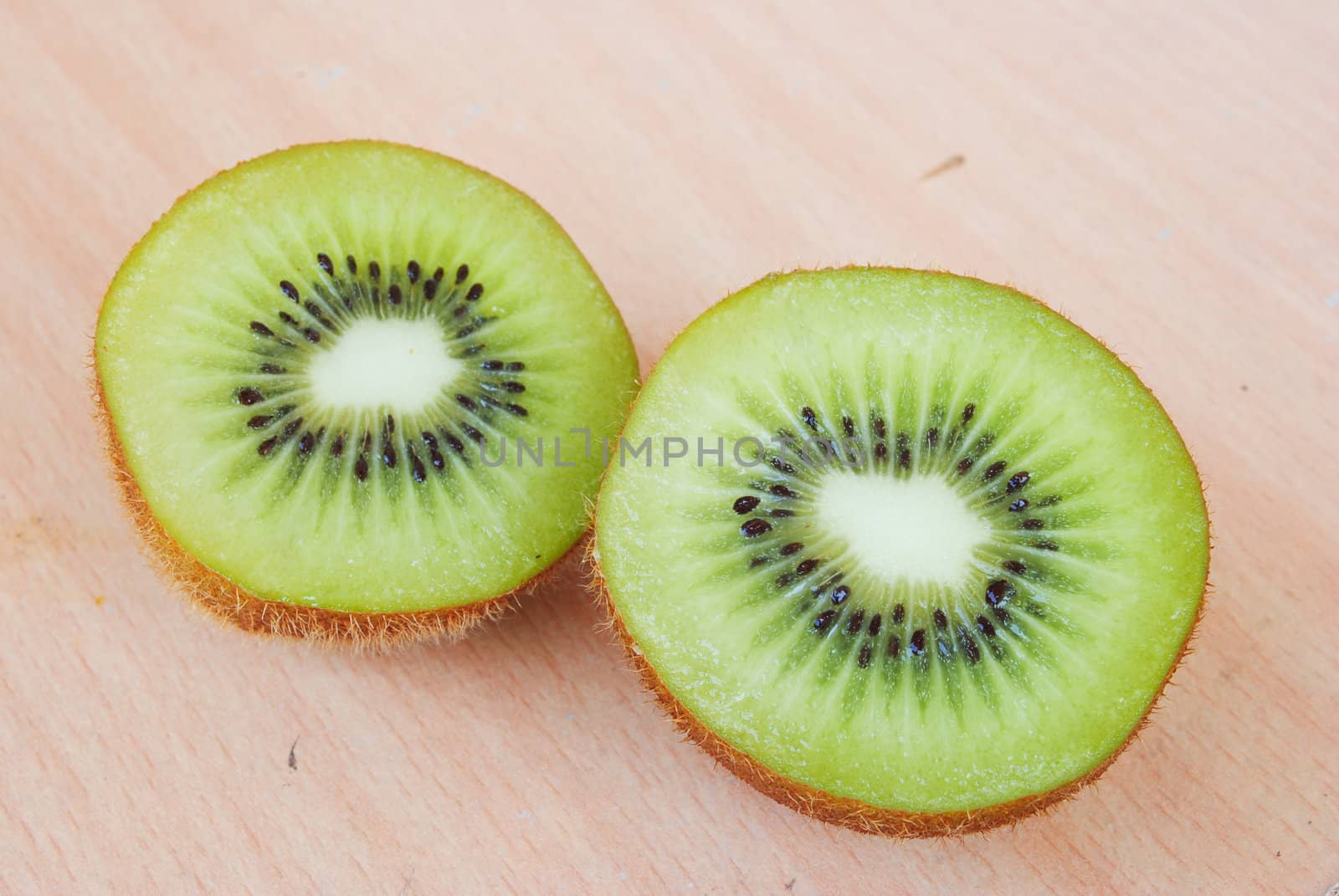 Fresh kiwis on wooden ground