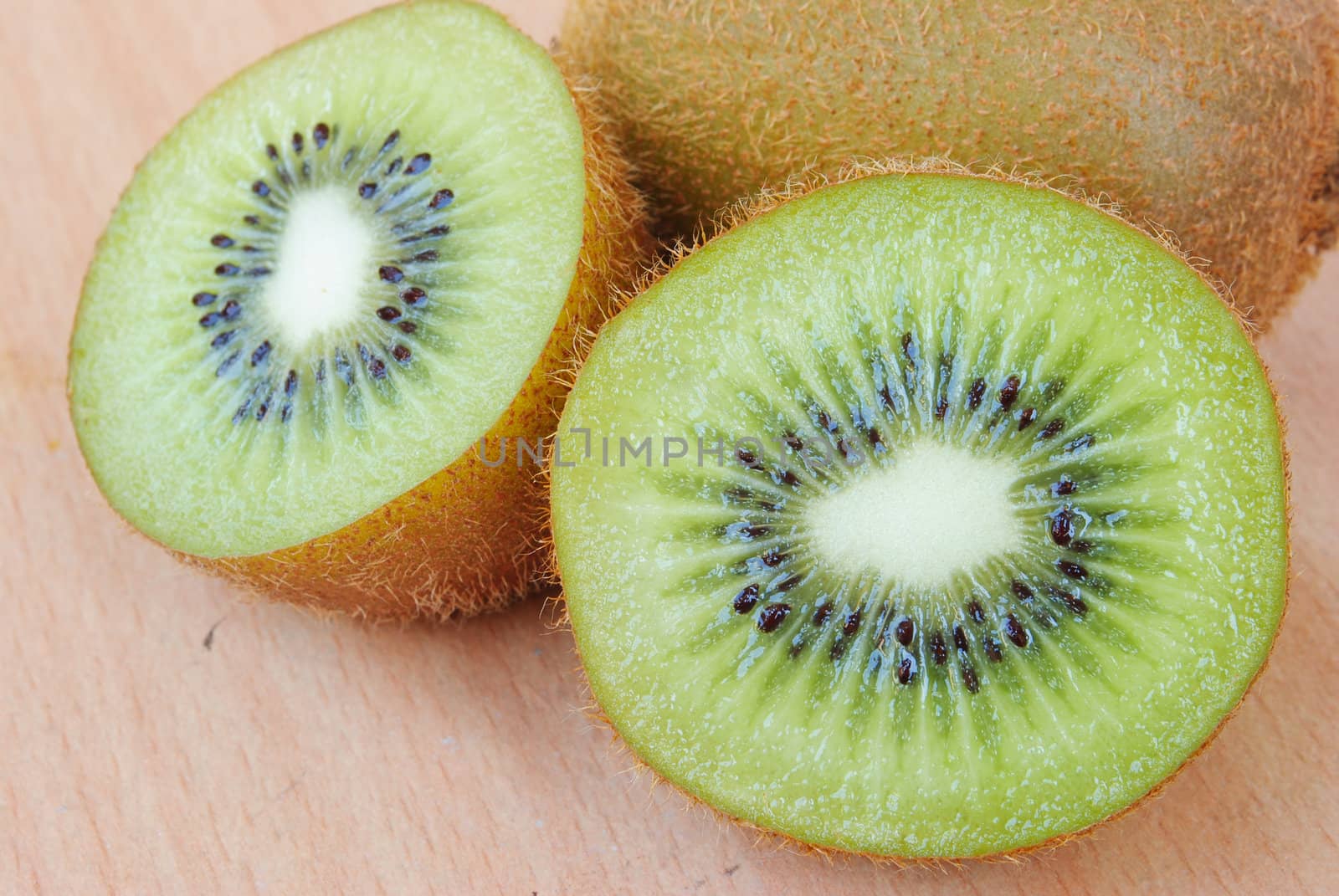 Fresh kiwis on wooden ground