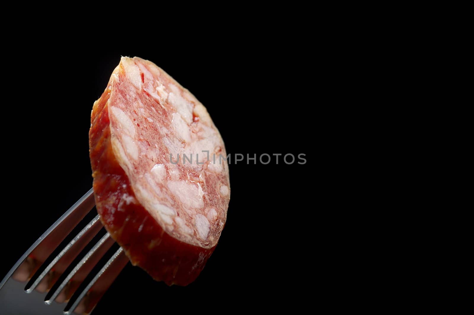 piece of the sausage on the fork.Salame Italiano
