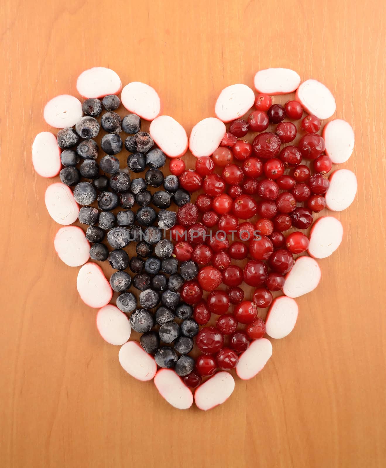 Frozen cranberries and  blackberry are laid out in the form of heart close-up