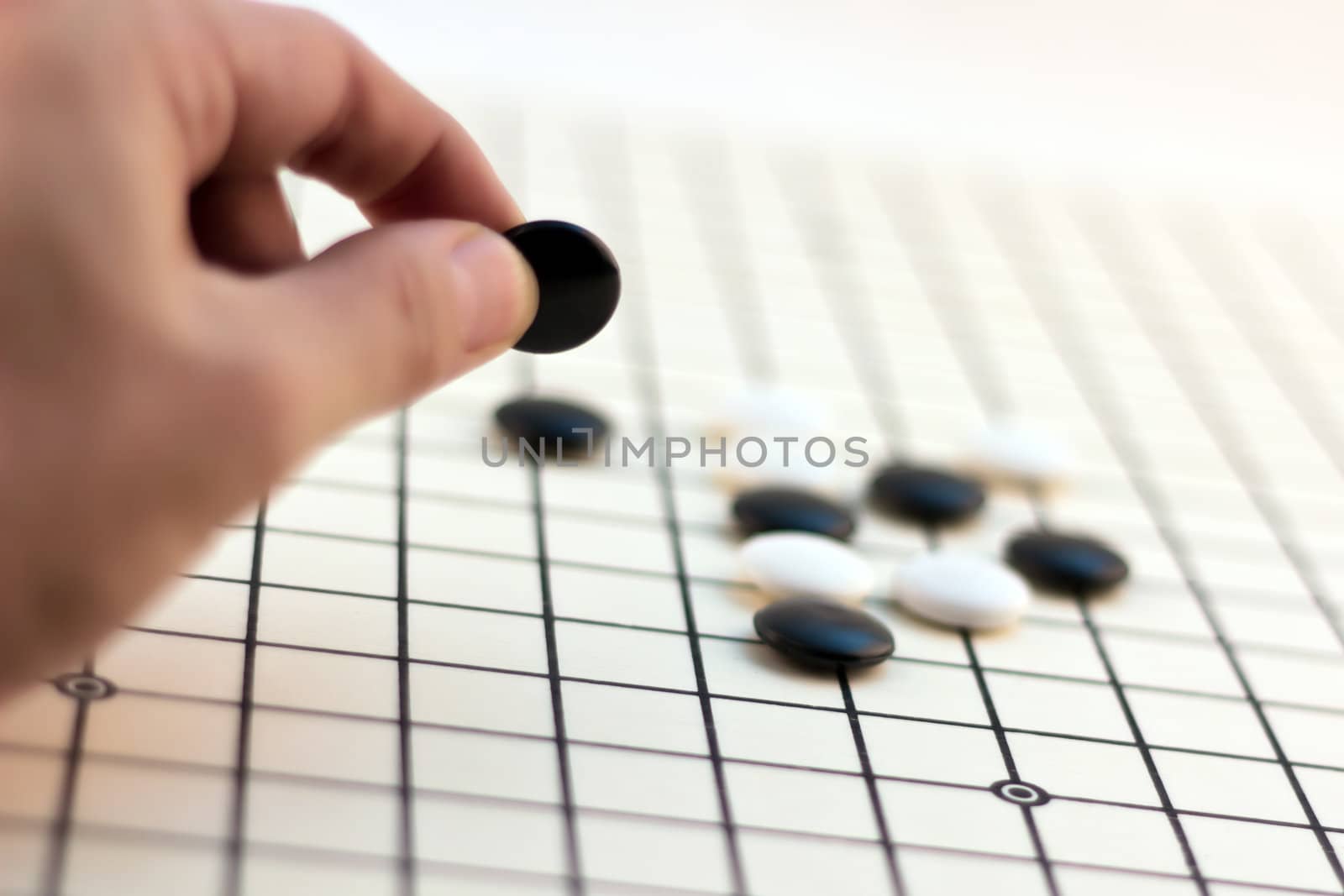 Traditional Chinese Board Game - Go (Male hand playing his move)