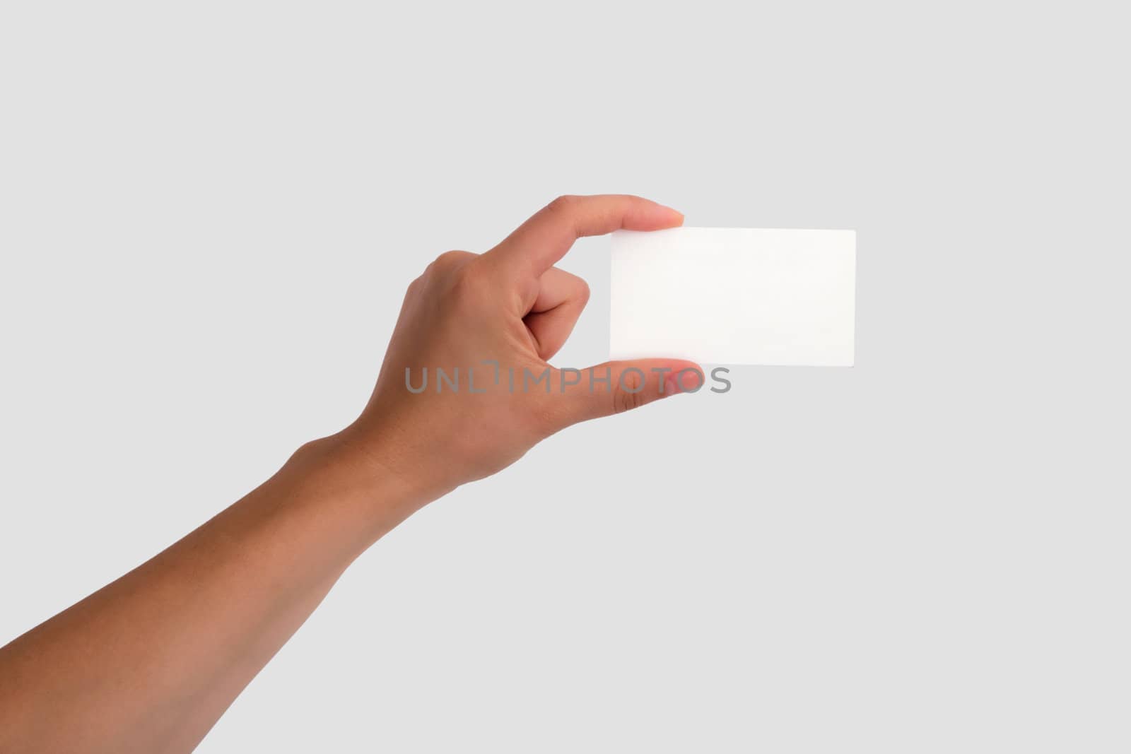 Female Hand Holding a Blank Business Card. Isolated on light grey background.