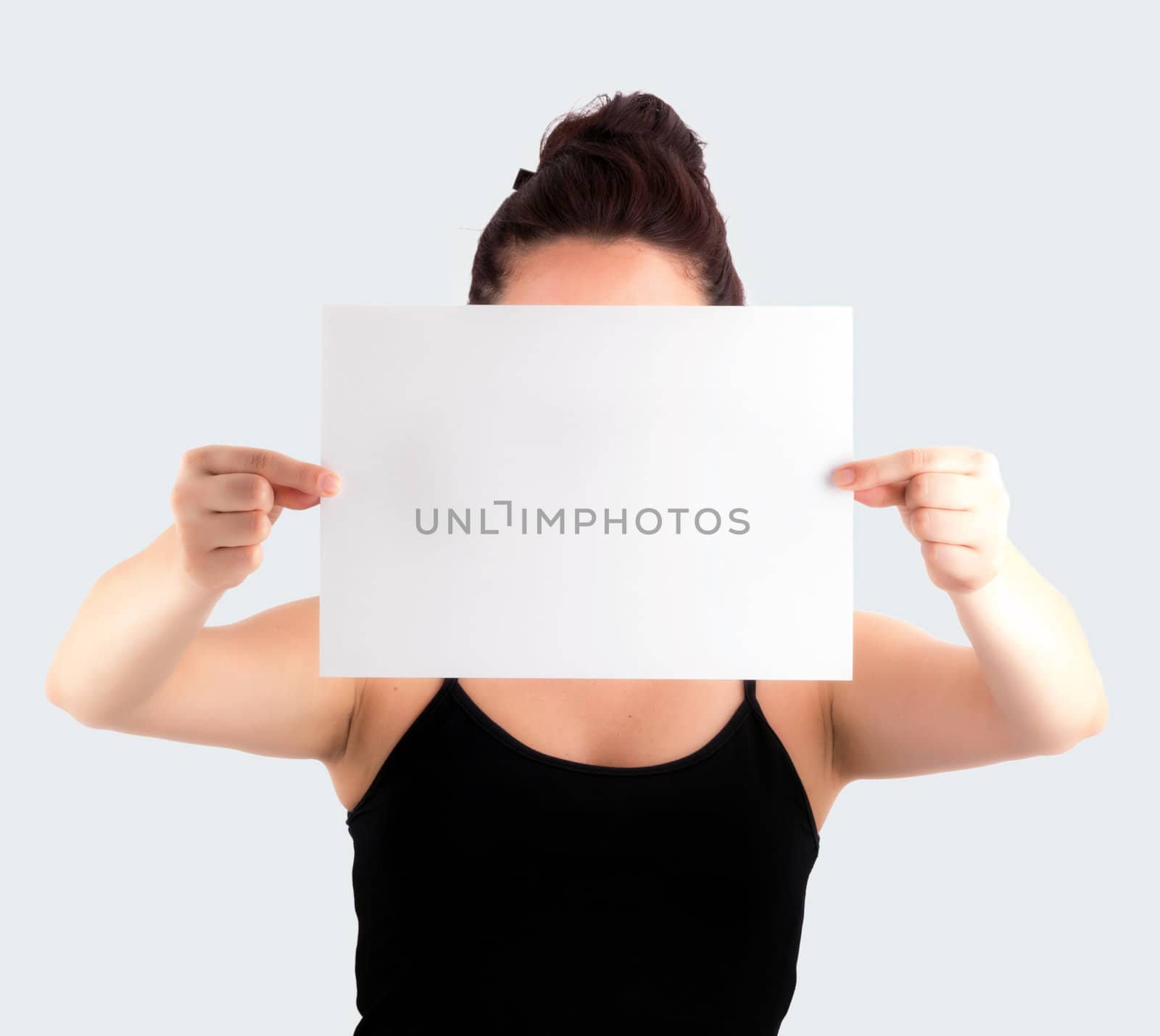 Young Casual Woman Holding a Blank Signboard - Paper with her two hands, isolated on light grey background. (No face shown)