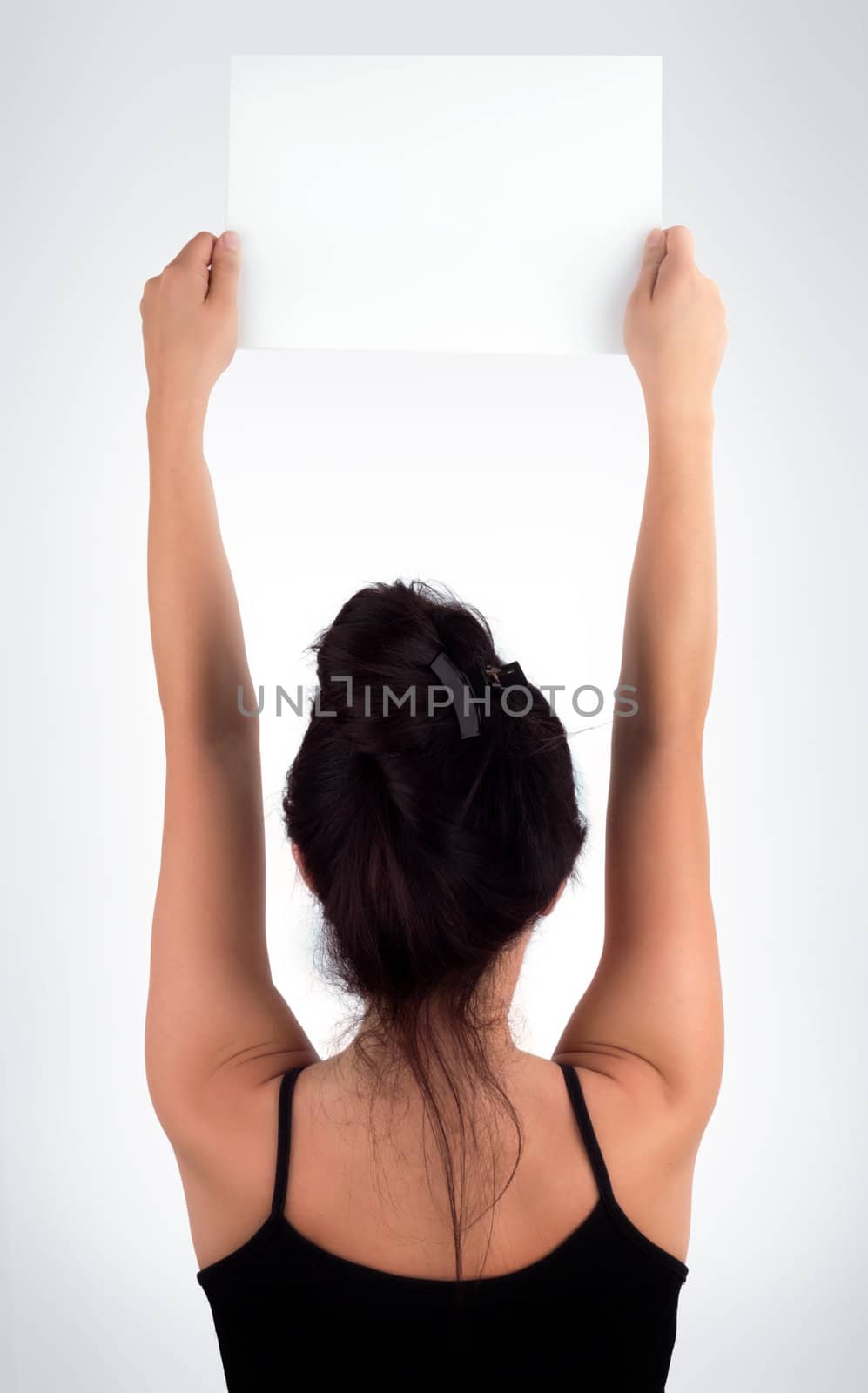 Young Casual Woman Face Back Holding a Blank Signboard - Paper with her two hands, isolated on light grey background