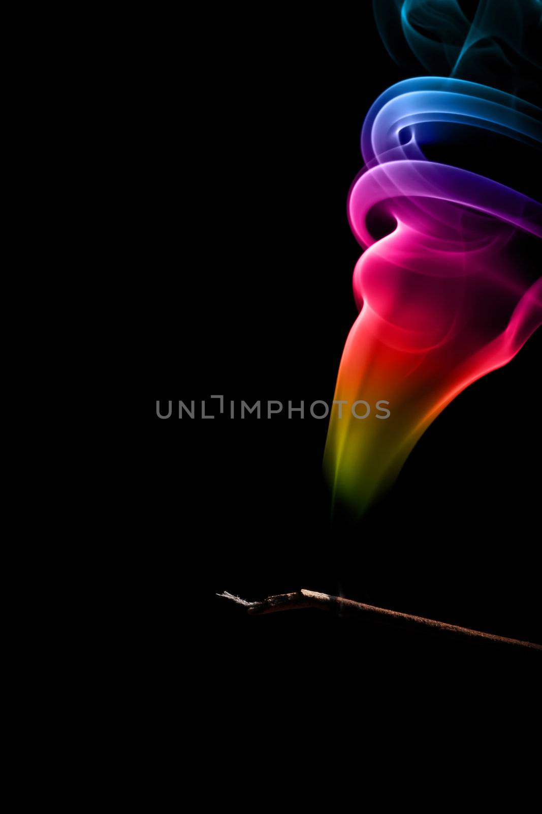 Incense Stick with Colorful Abstract Smoke Trail on black background