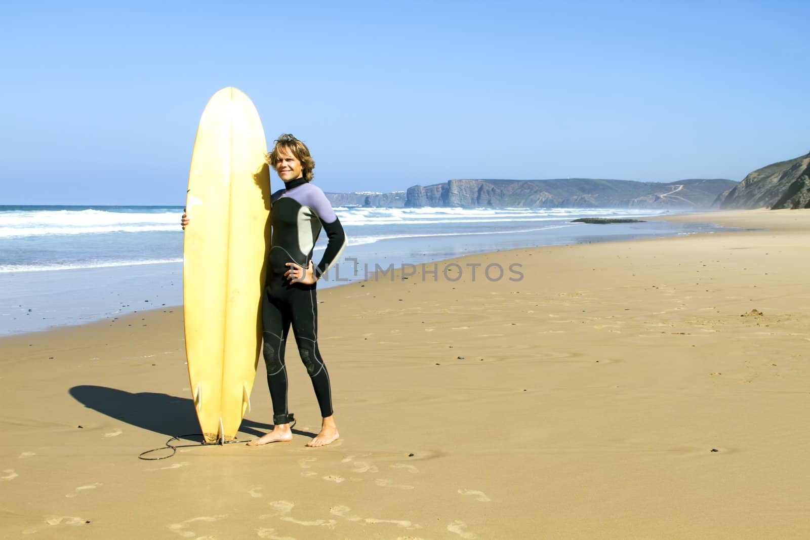 Surfer with his surfboard at the beach