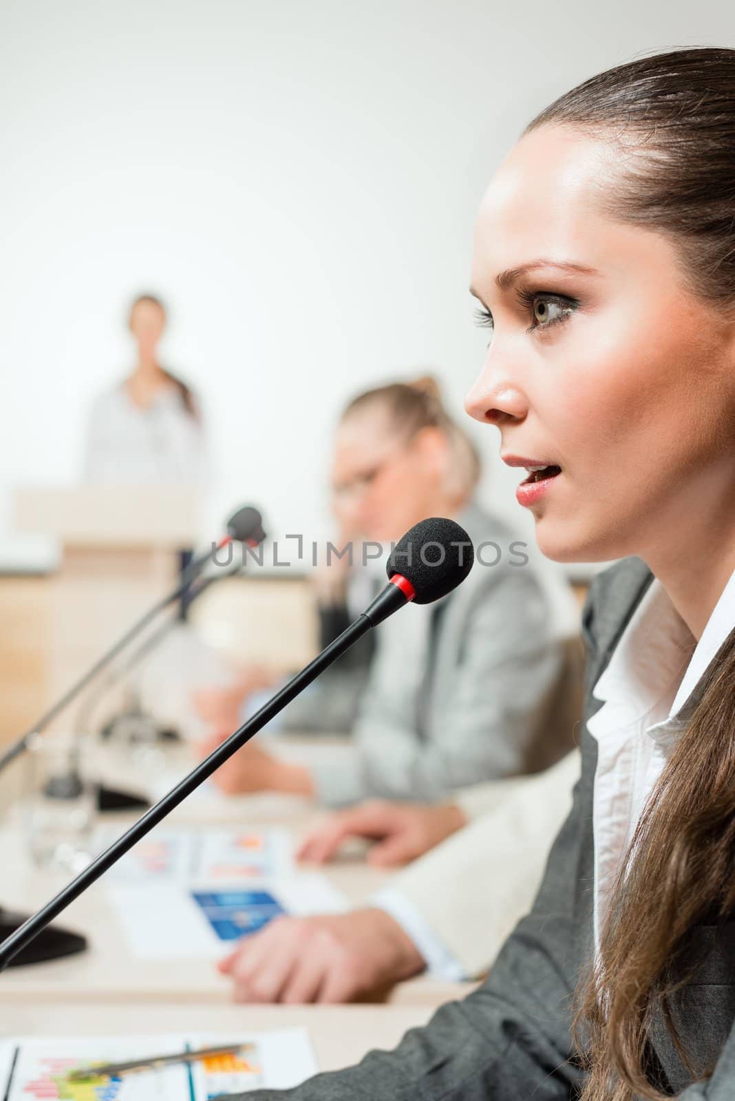 businessmen talking at the conference, sitting at the table, on the table microphones and documemts