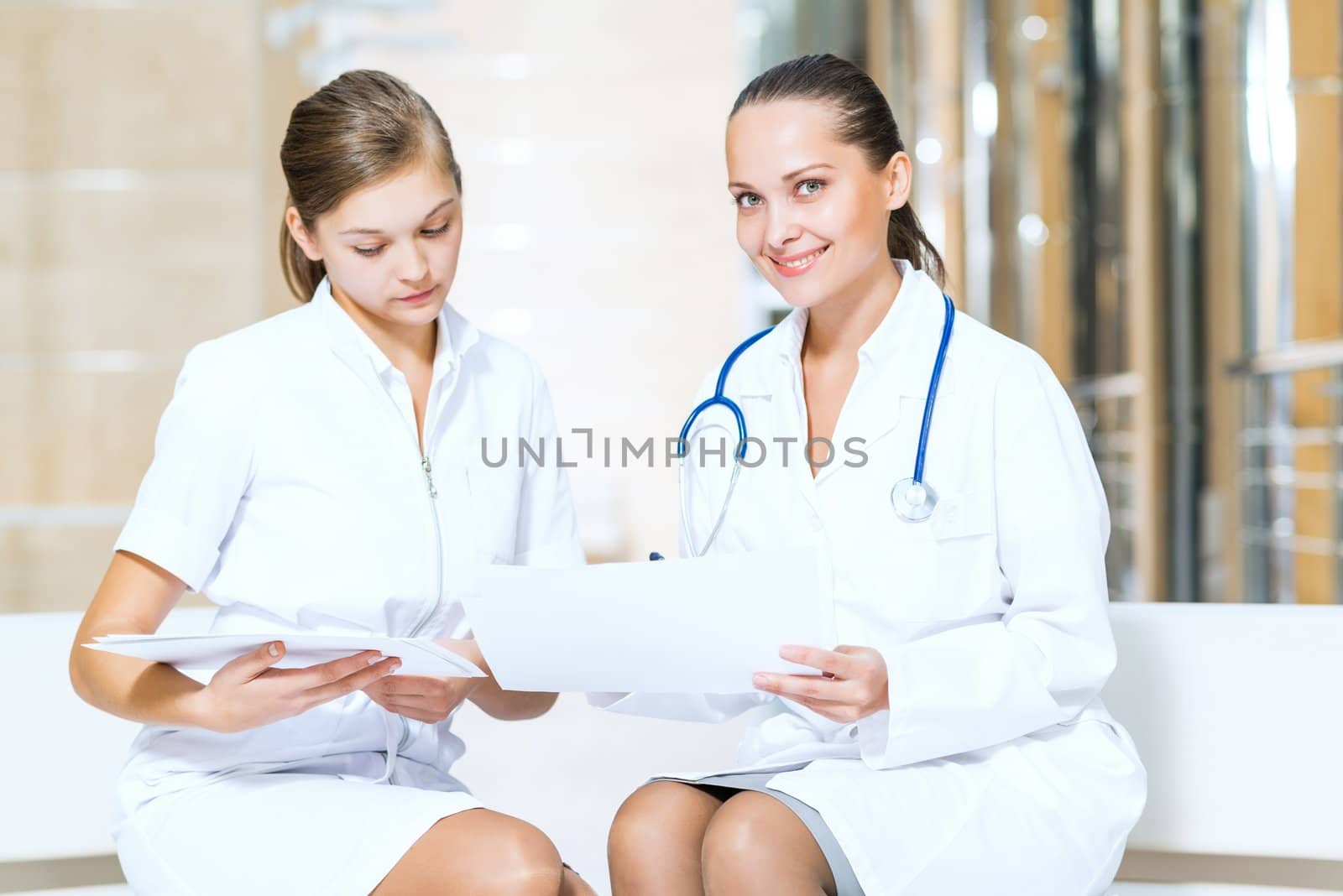 two doctors talking in the lobby of the hospital, sitting on the couch