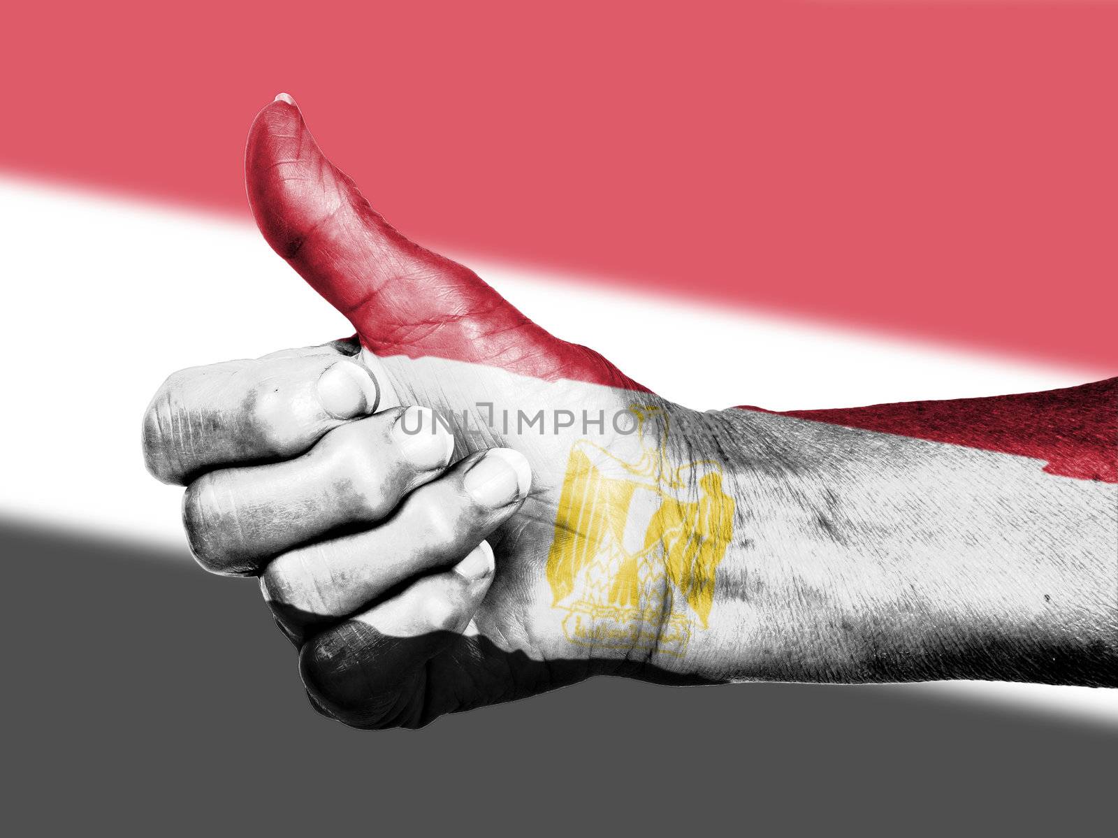 Old woman with arthritis giving the thumbs up sign, wrapped in flag pattern, Egypt