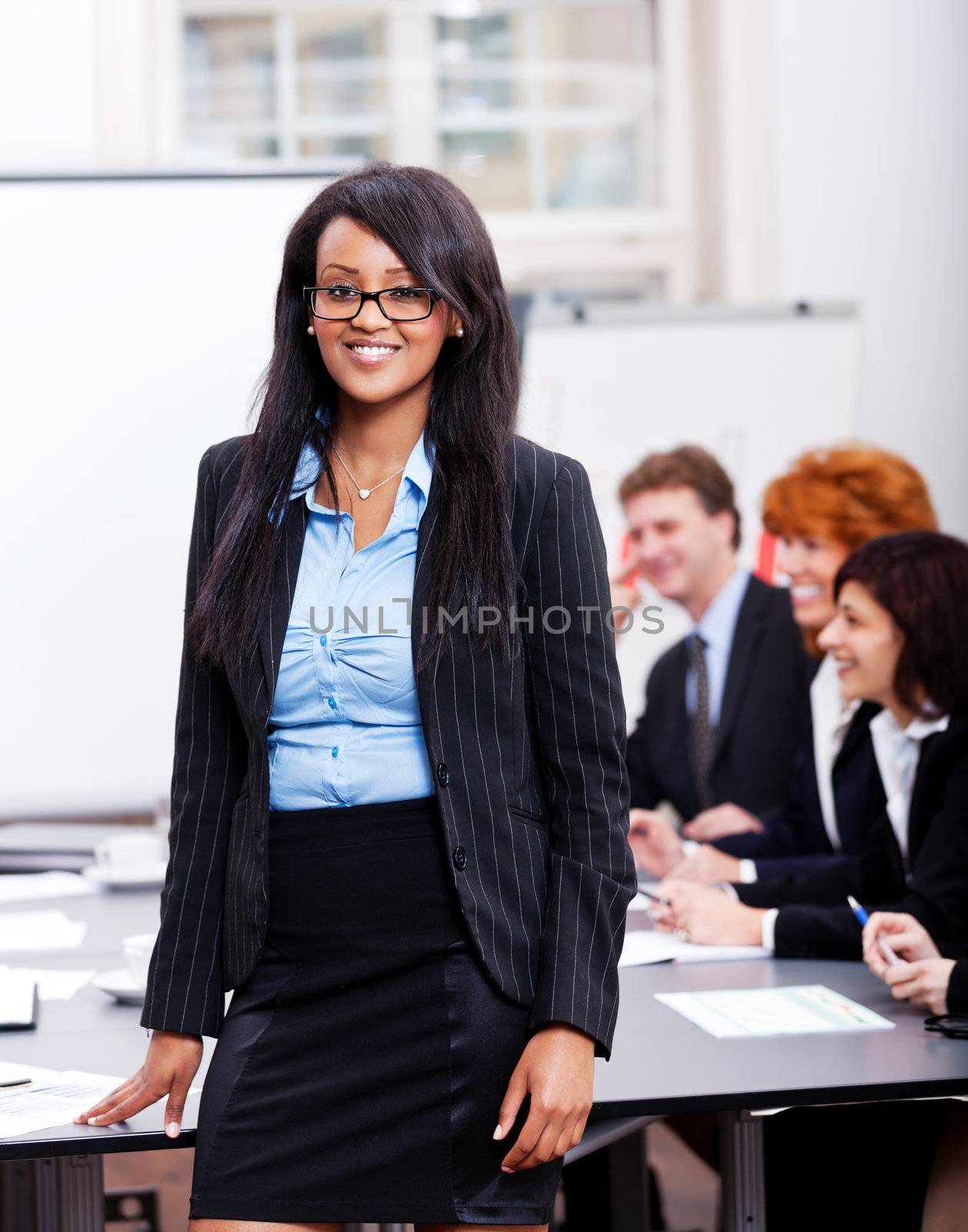 professional successful smiling business woman in office with team in background