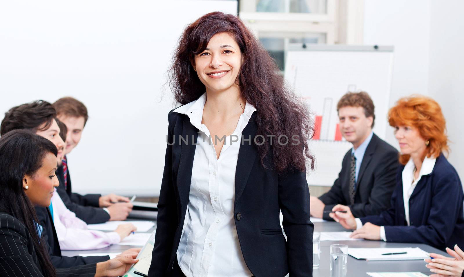 professional successful smiling business woman in office with team in background