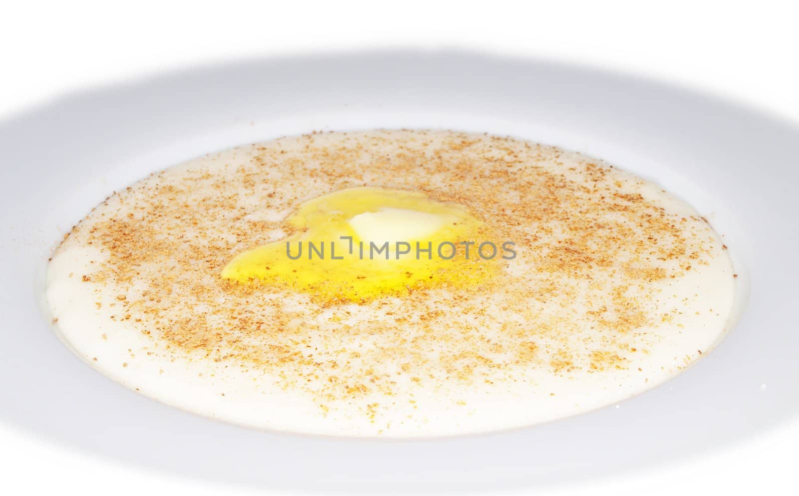 Porridge in a deep bowl with butter eye by Arvebettum