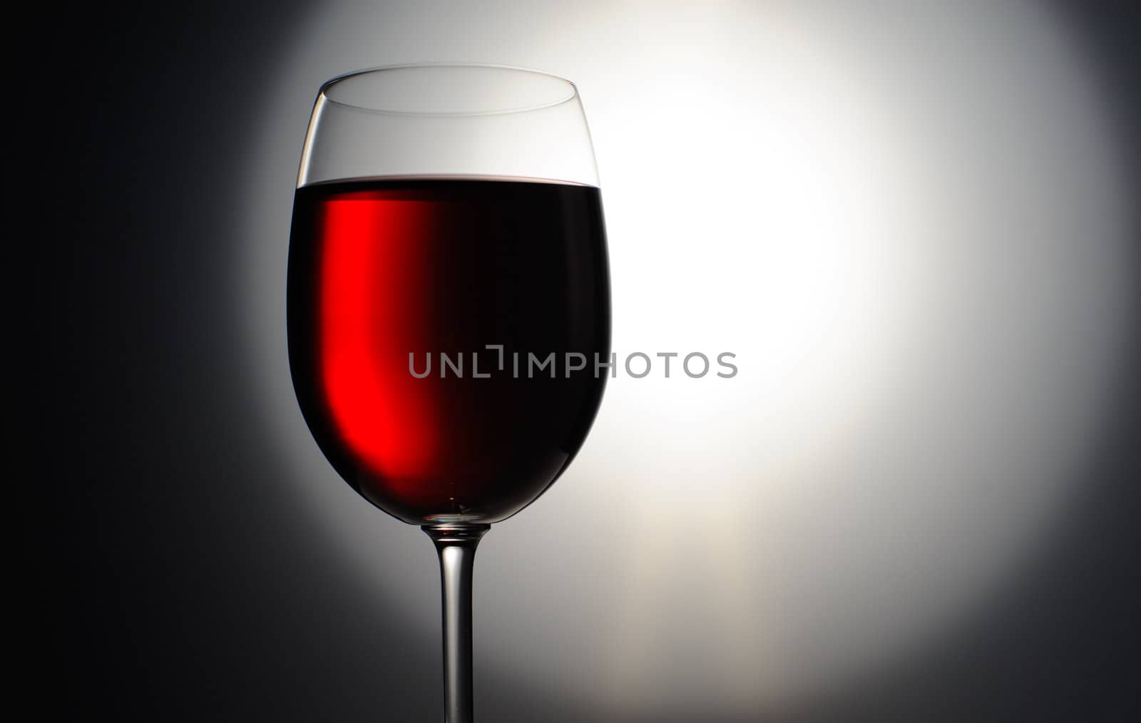 Closeup of red wine wineglass on dark background