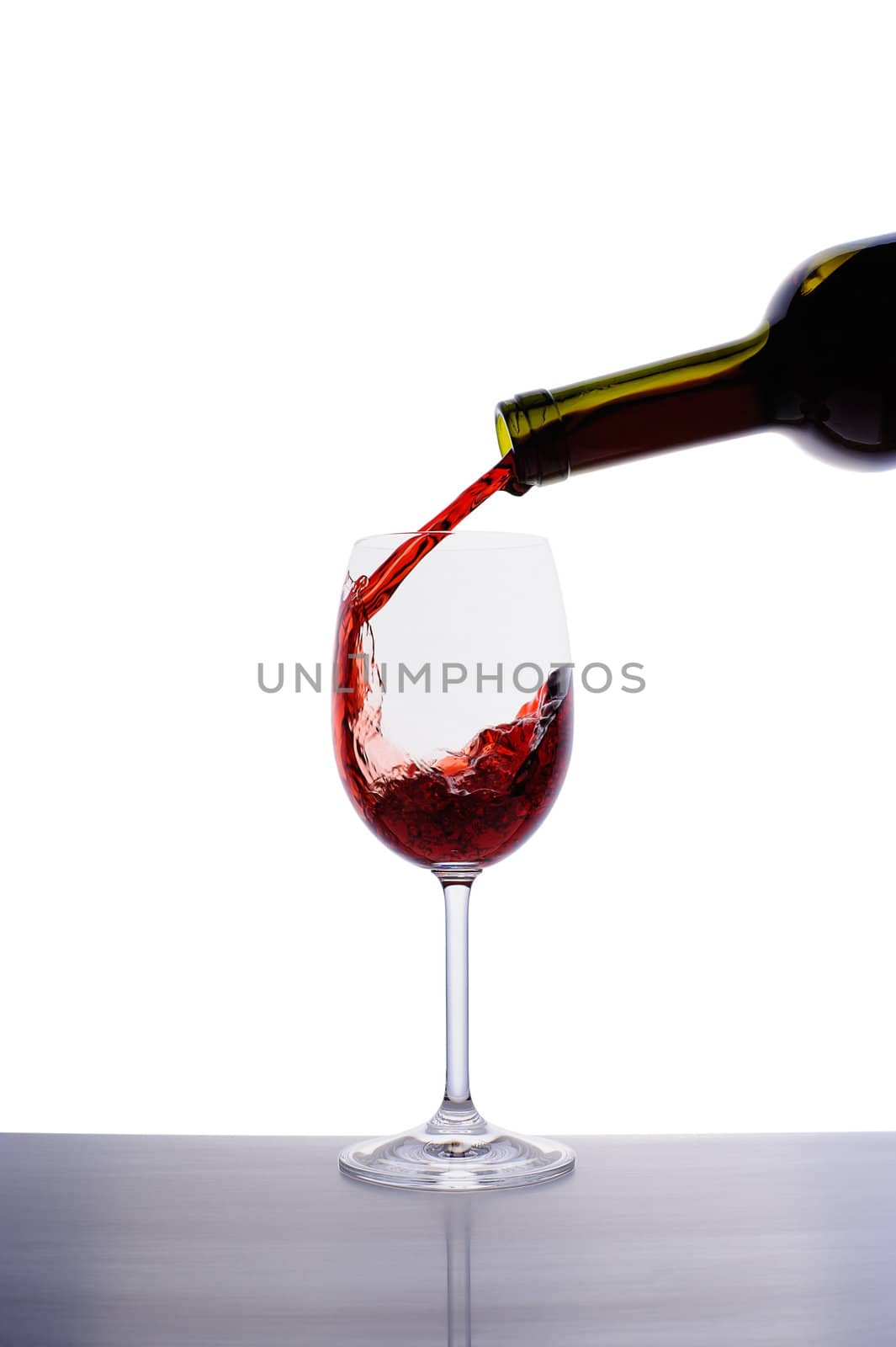 Red wine pouring into wine glass by nvelichko