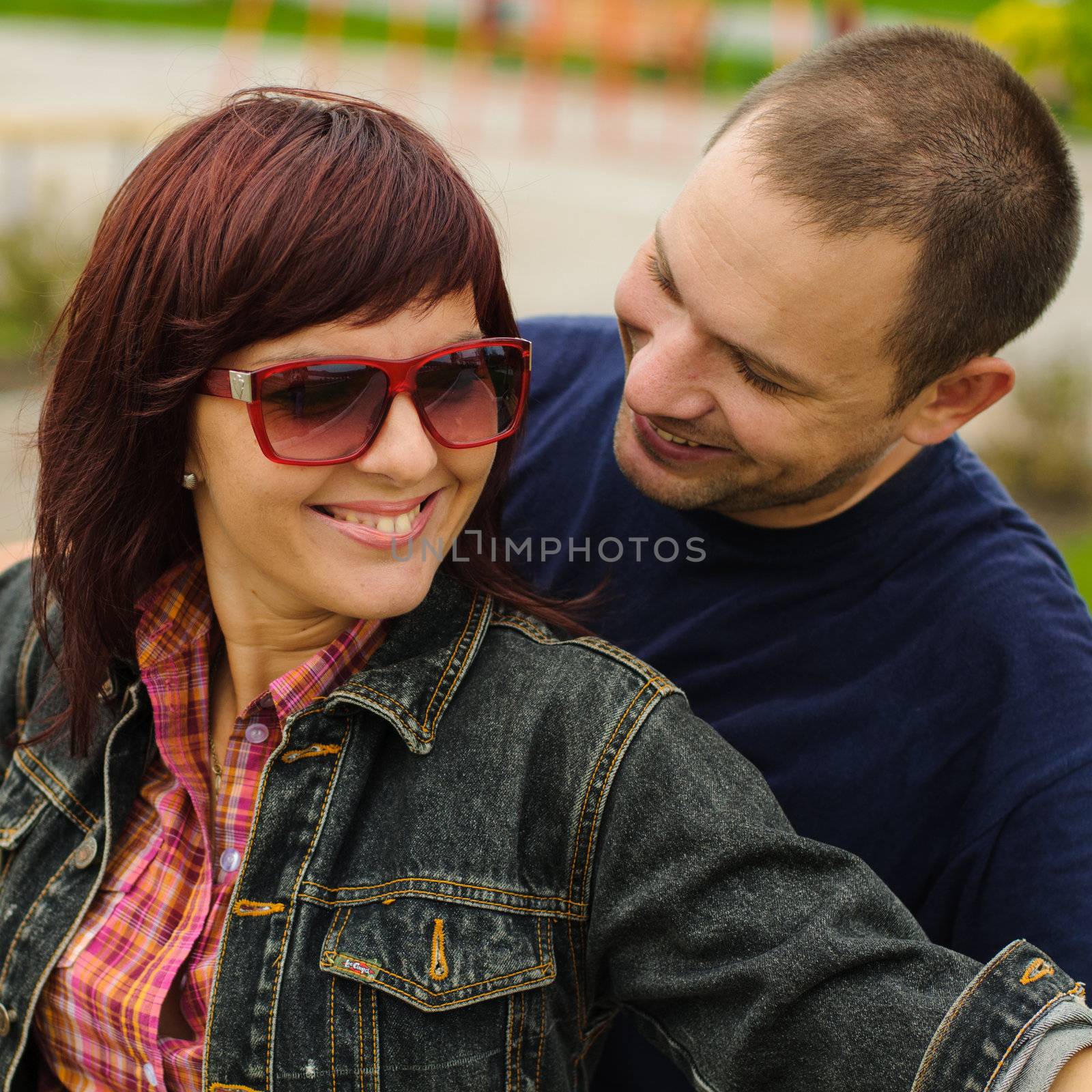 Good looking couple in love smiles each other outdoor