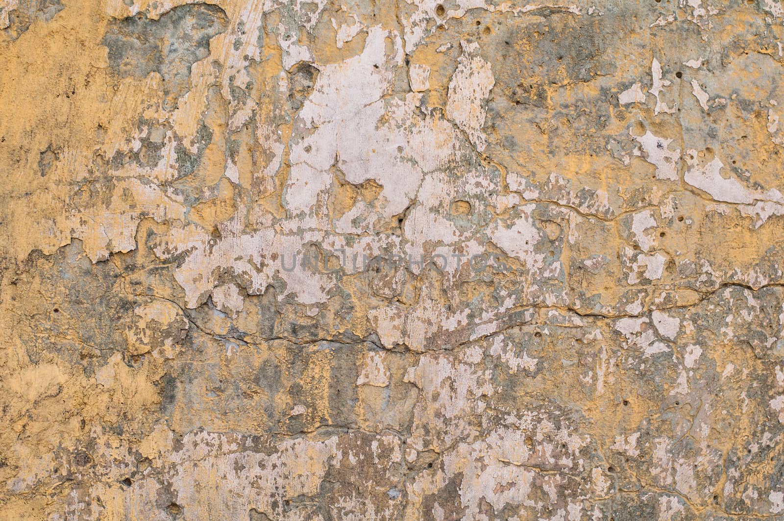 Old yellow grunge painted wall with brown spots