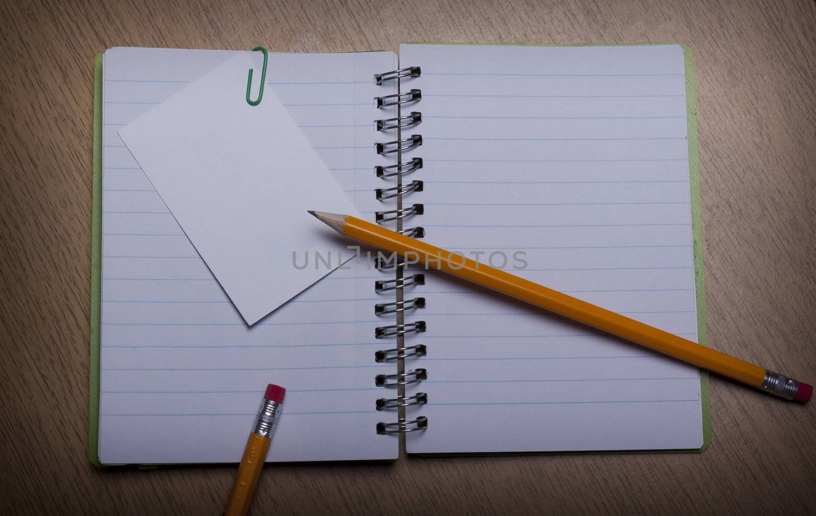 open  notebook on a wooden desk with pencil