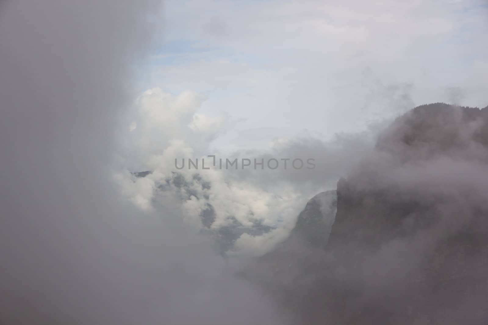 A picture trough some clouds of some mountains.